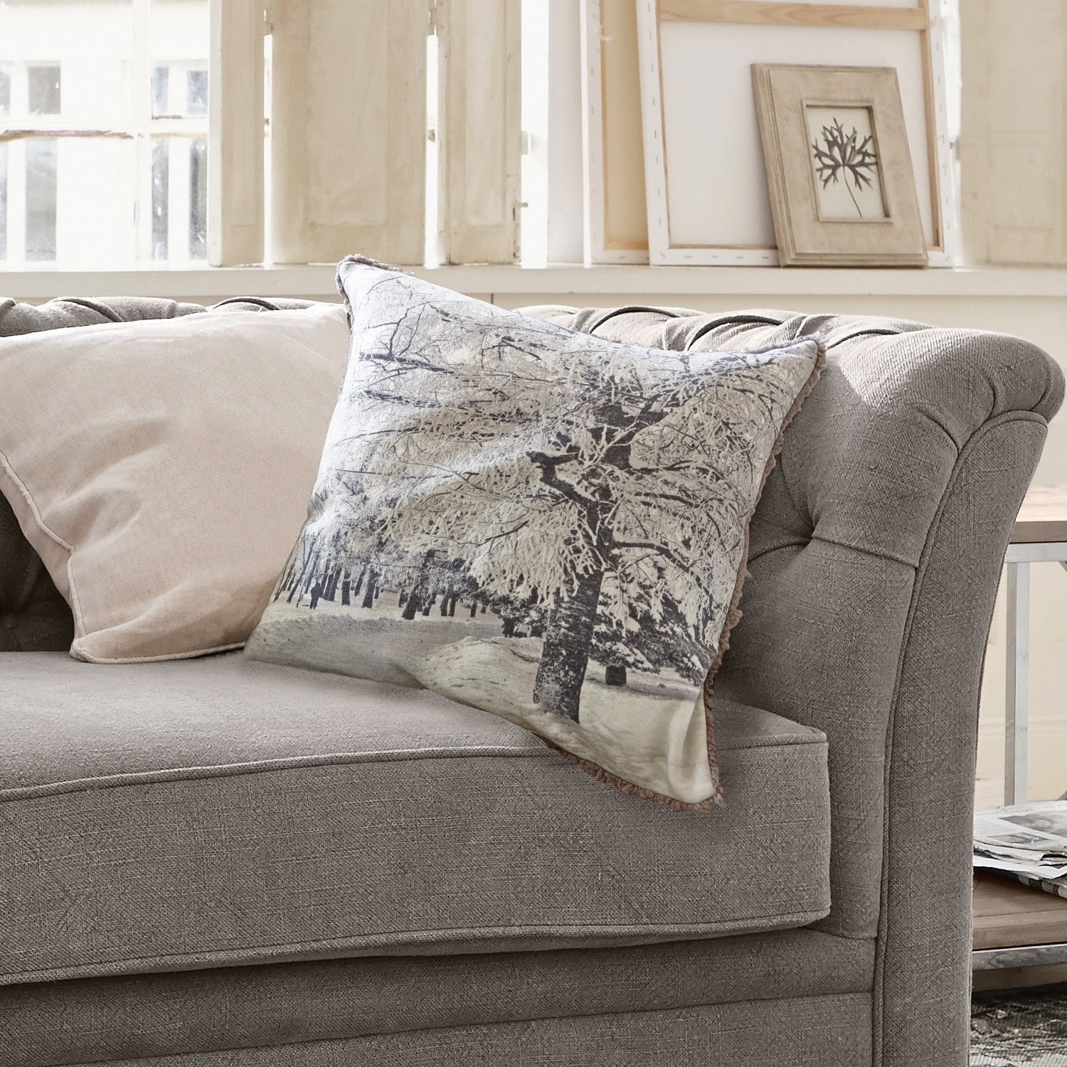 Kissen Forrest Graues Sofa mit zwei Kissen, eines mit Winterbaum-Motiv, gemütliche Wohnzimmerdekoration