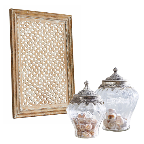 Holzrahmen mit filigranem Muster und zwei dekorativen Glasgefässen mit Metalldeckeln im Vintage-Stil