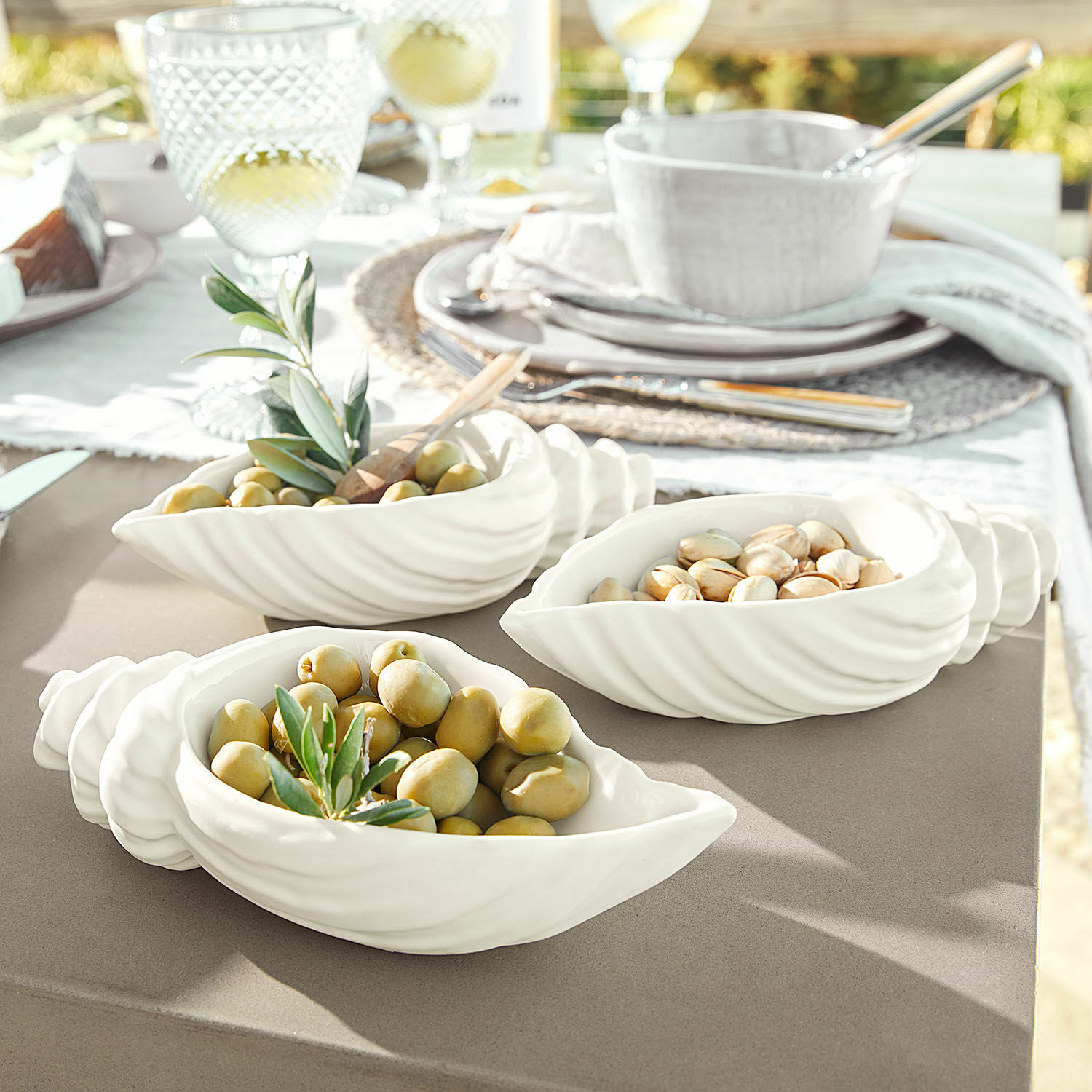 Schale 3er Set Portavin Weisse Keramikschalen in Muschelform mit Oliven und Nüssen auf Gartentisch