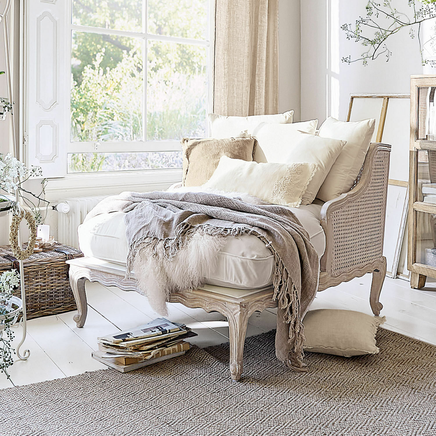 Chaiselongue Dronne Beiges Sofa aus Holz und Rattan mit cremefarbenen Kissen und weicher Decke in hellem Raum