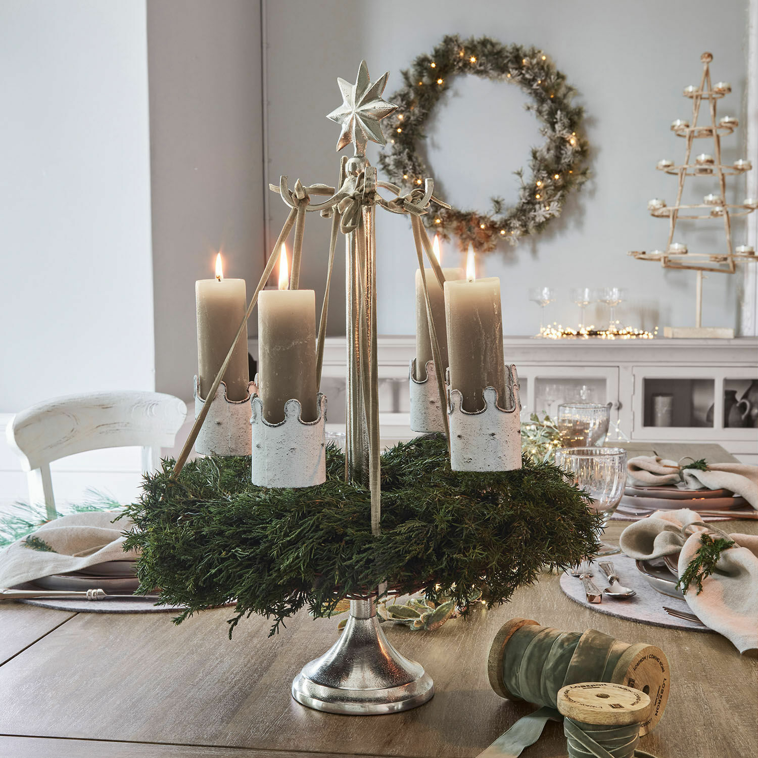 Kranzständer Graham Metall-Adventskranz mit grünem Kranz und vier beigen Kerzen auf Holztisch dekoriert