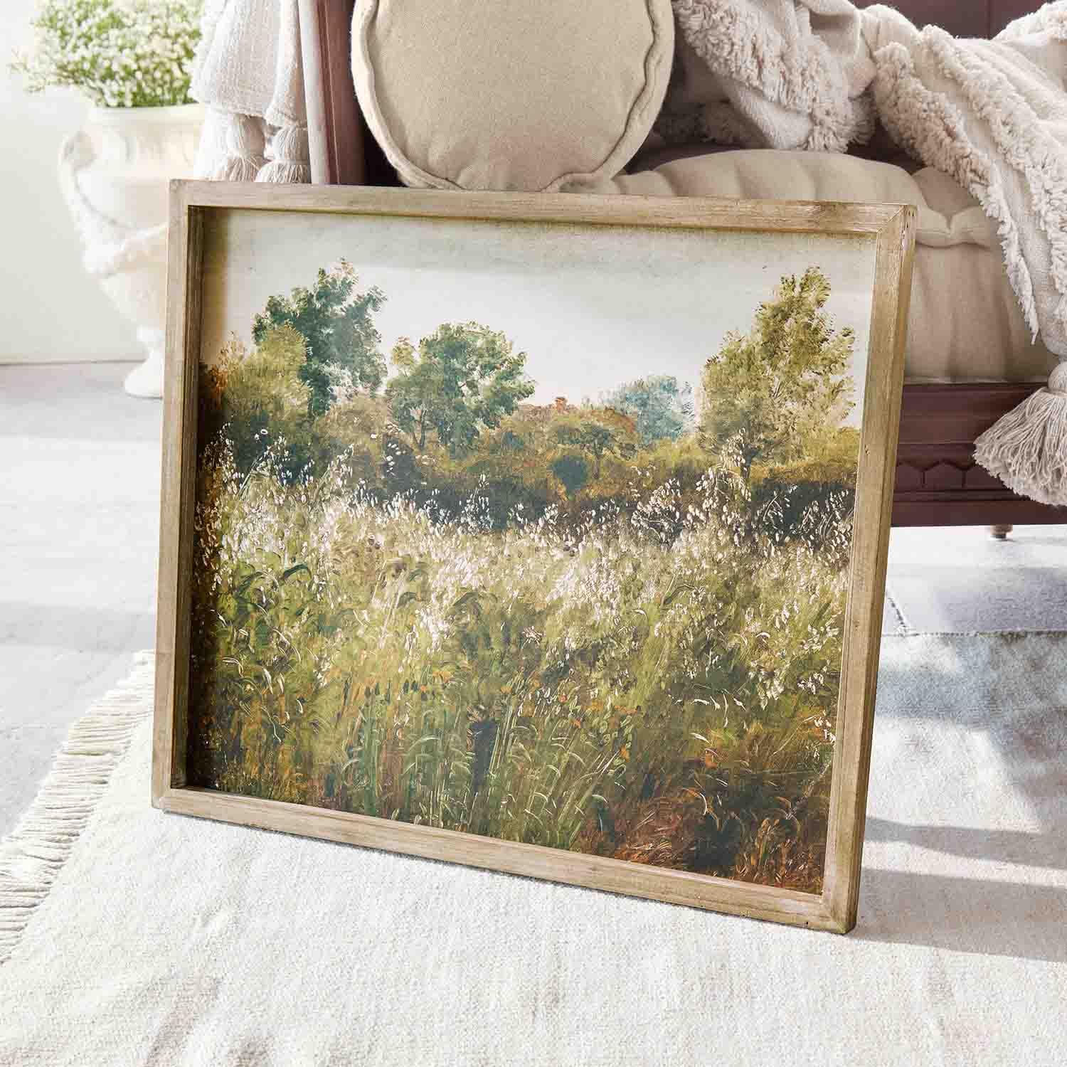 Gemälde einer Landschaft mit grünen Bäumen und Wiese in Holzrahmen auf hellem Teppich