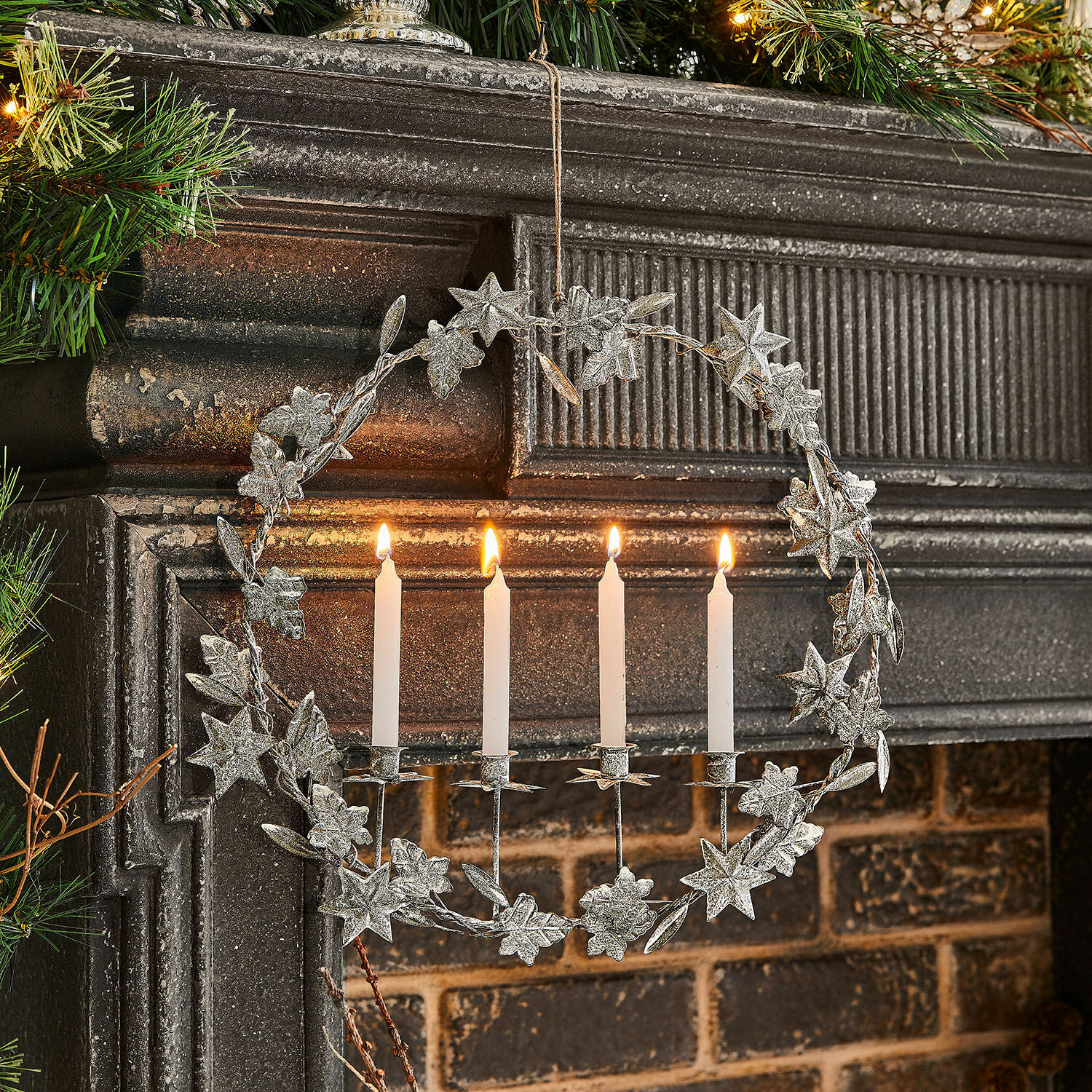 Kerzenhalter Jolvent Metallkranz mit weissen Kerzen und sternförmigen Verzierungen am Cheminée, festliche Weihnachtsdekoration