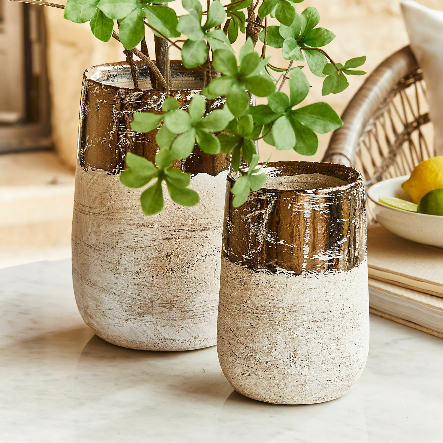 Vase 2er Set Hafira Zwei beige-braune Keramikvasen auf einer Marmorplatte, dekoriert mit grünen Blättern