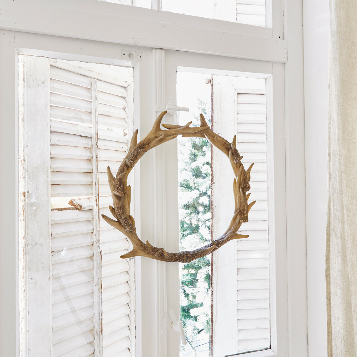 Kranz Marcelle Dekorativer Holzkranz in Geweihform am weissen Fenster mit Kerzen und Tannenzapfen
