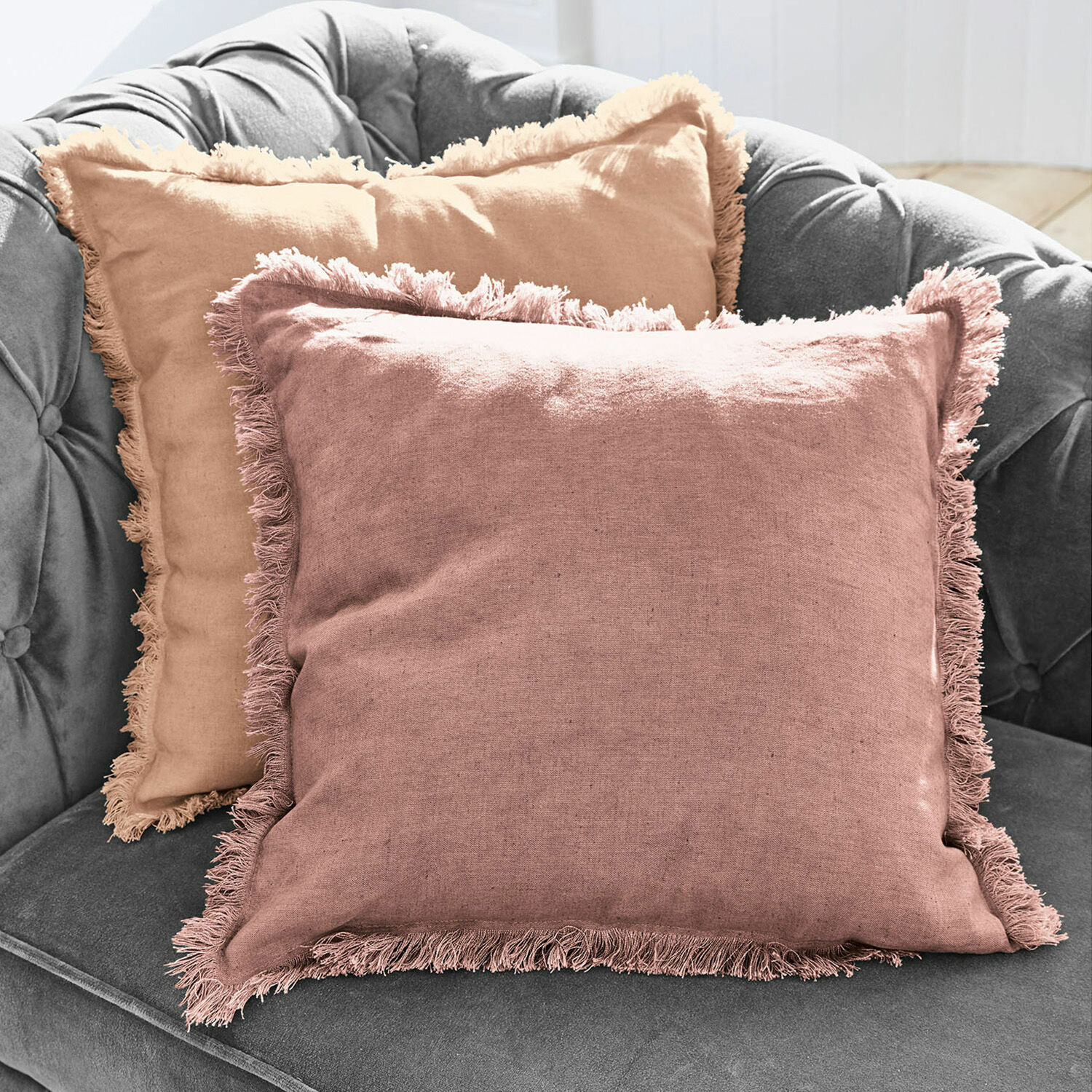 Kissenhülle 2er Set Quebo Set aus zwei dekorativen Leinenkissen mit Fransen in Rosa und Beige auf grauem Sofa