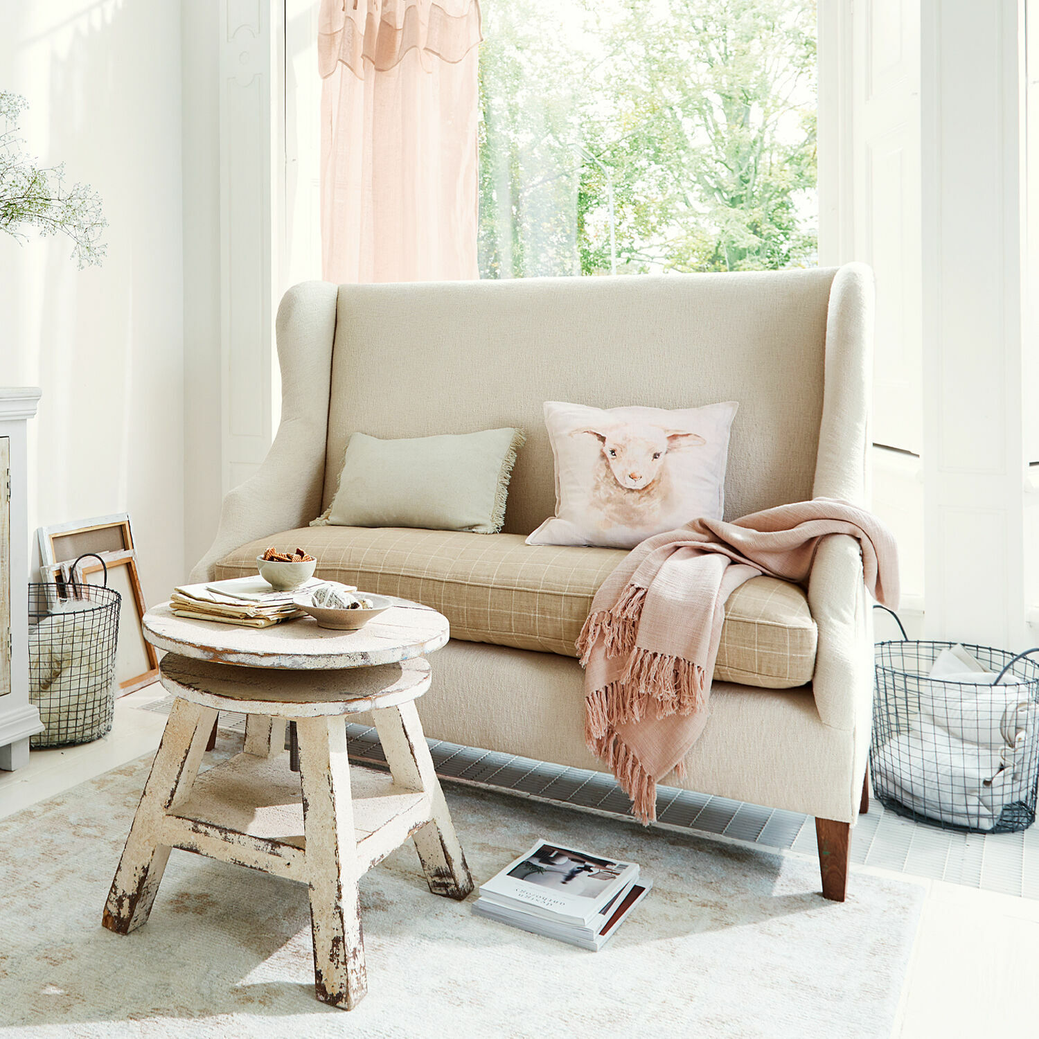 Sofa Ombra Beige Stoffcouch mit Kissen mit Lamm-Motiv und rustikalem Holzcouchtisch im hellen Wohnzimmer