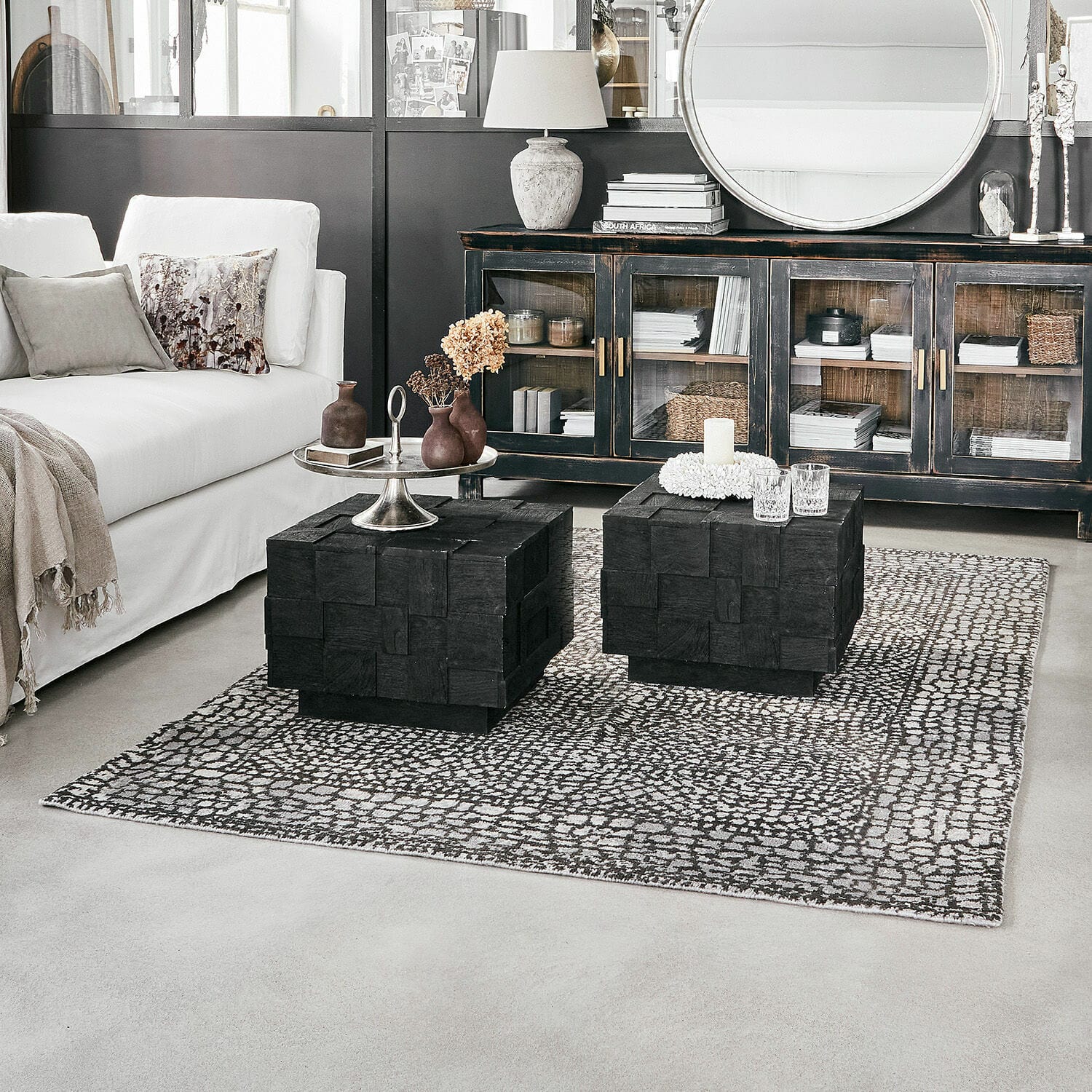 Teppich Vermont Modernes Wohnzimmer mit weissem Sofa und schwarzen Holzcouchtischen auf gemustertem Teppich