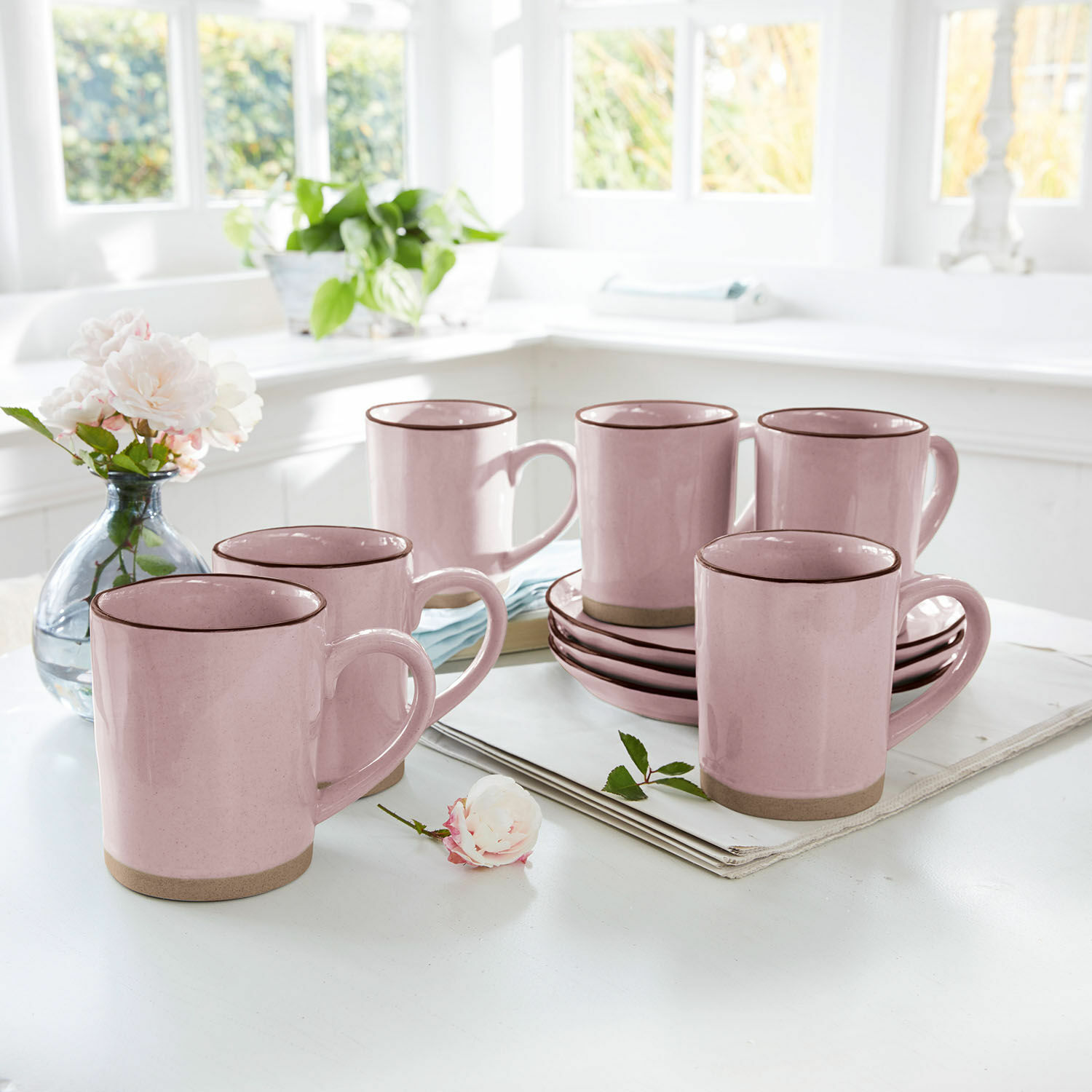 Tasse 6er Set Biarré Set aus rosa Keramiktassen mit braunem Rand und Untertassen auf hellem Küchentisch