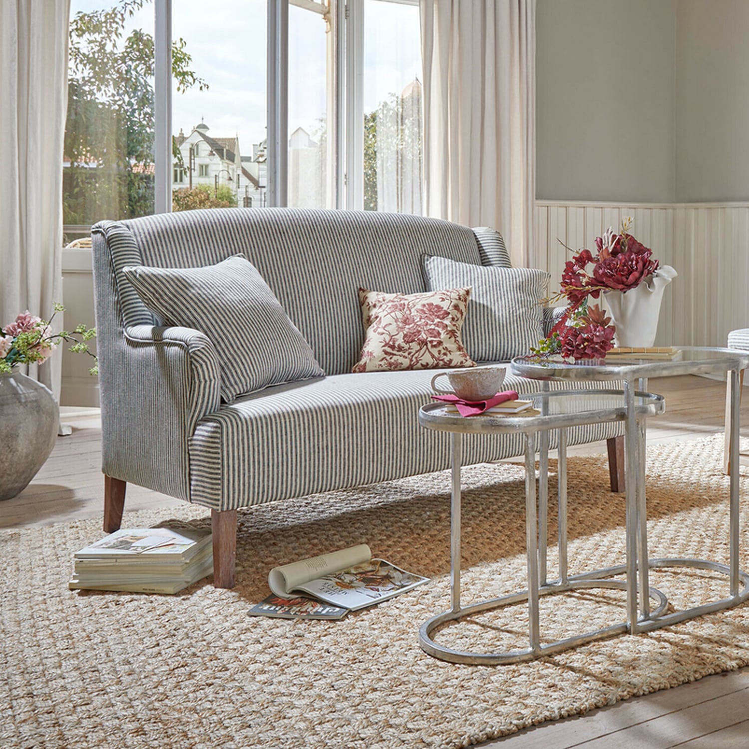 Gestreiftes Sofa aus Stoff in Grau-Weiss mit Kissen und Metall-Couchtischen in hellem Wohnzimmer