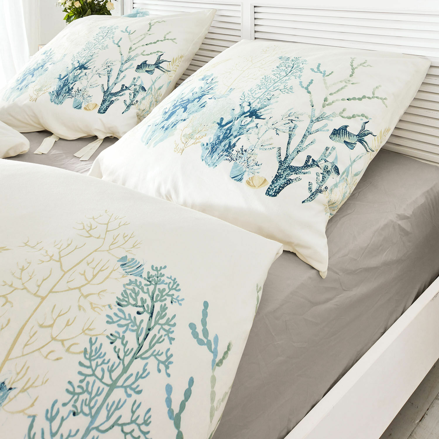 Bettwäsche Grosmagny Bettwäsche aus Baumwolle mit maritimen Motiven in Blau- und Beigetönen auf grauem Spannbettlaken.