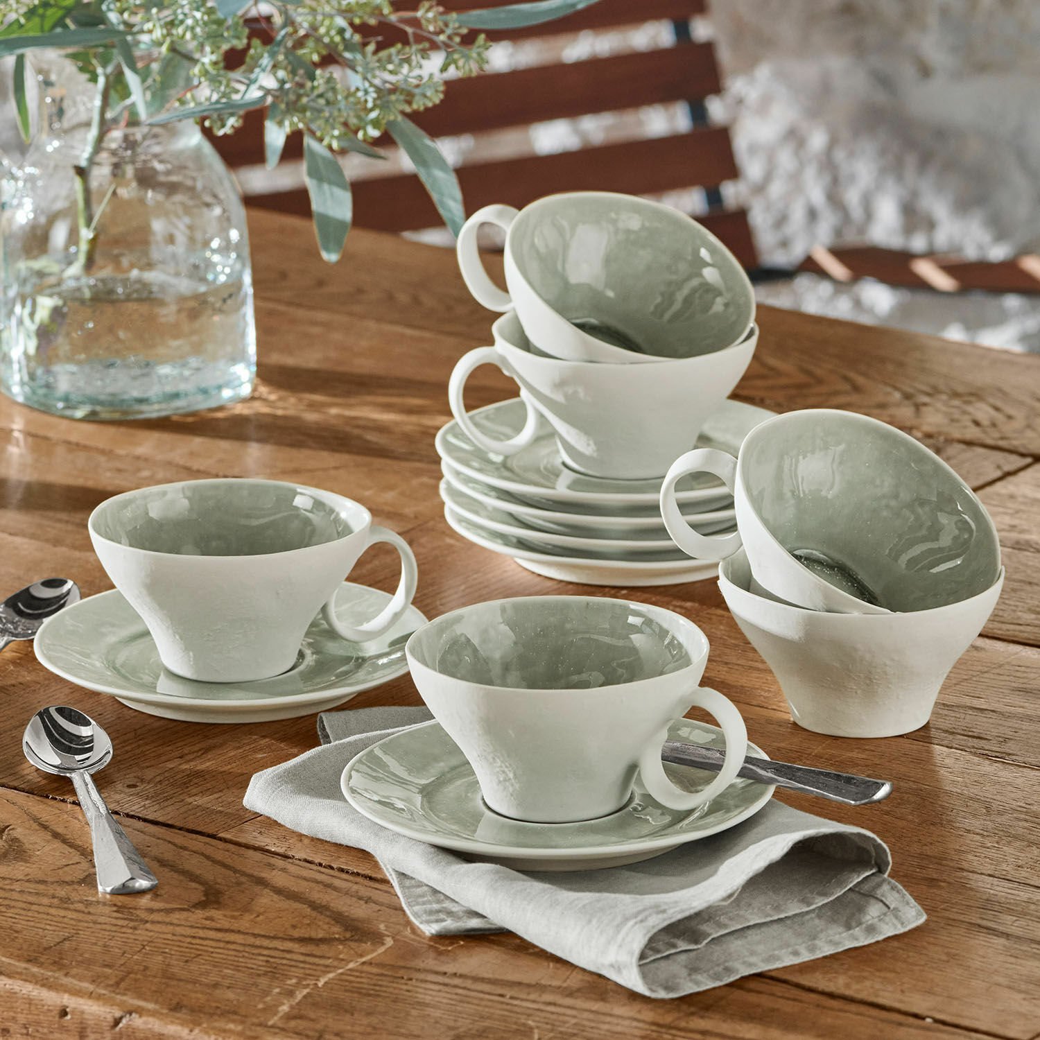 Tasse mit Untertasse 6er Set Braganza Set aus weissen Keramiktassen mit grünem Innenraum auf Holztisch mit Löffeln