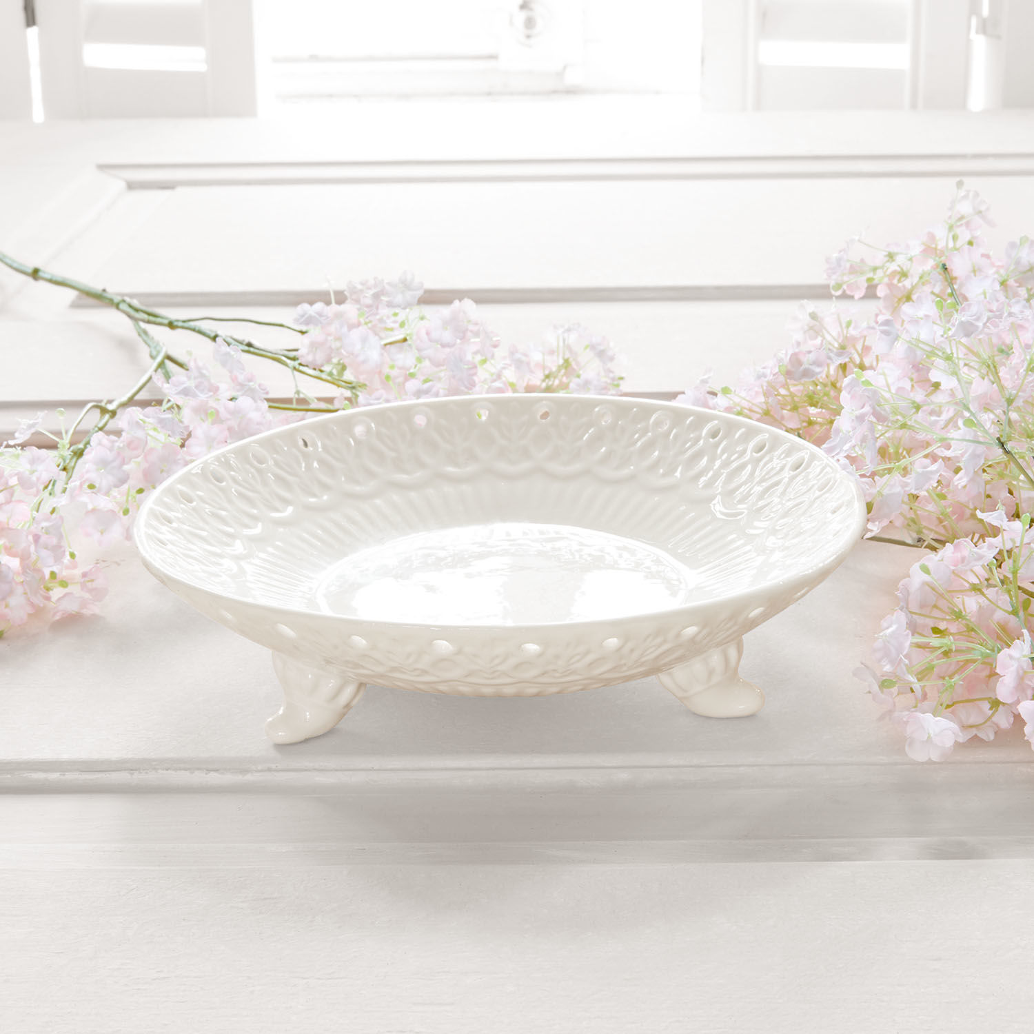 Weisse Keramikschale auf Füssen mit dekorativem Muster, stilvolles Wohnaccessoire