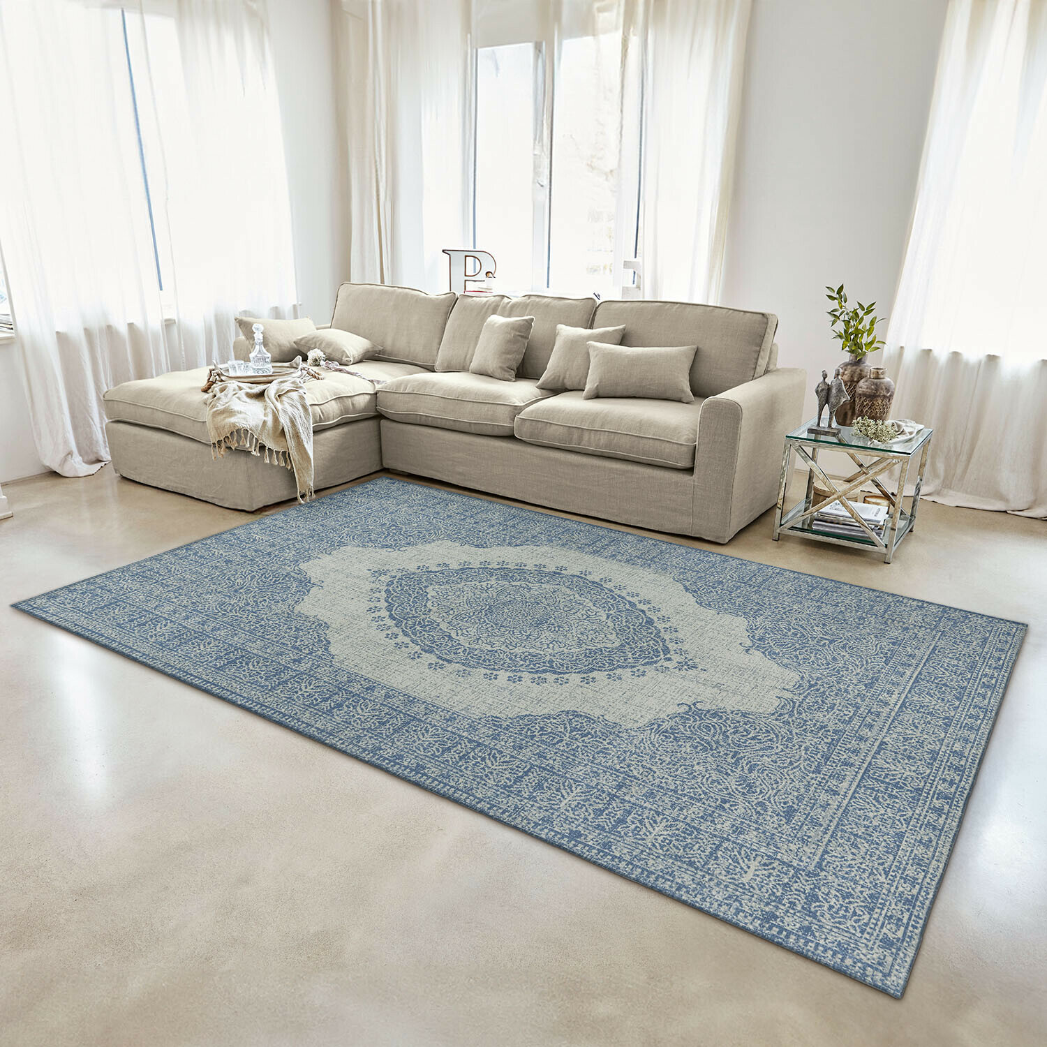 Dekorativer Teppich in Blau-Beige mit orientalischem Muster im modernen Wohnzimmer mit beigem Sofa