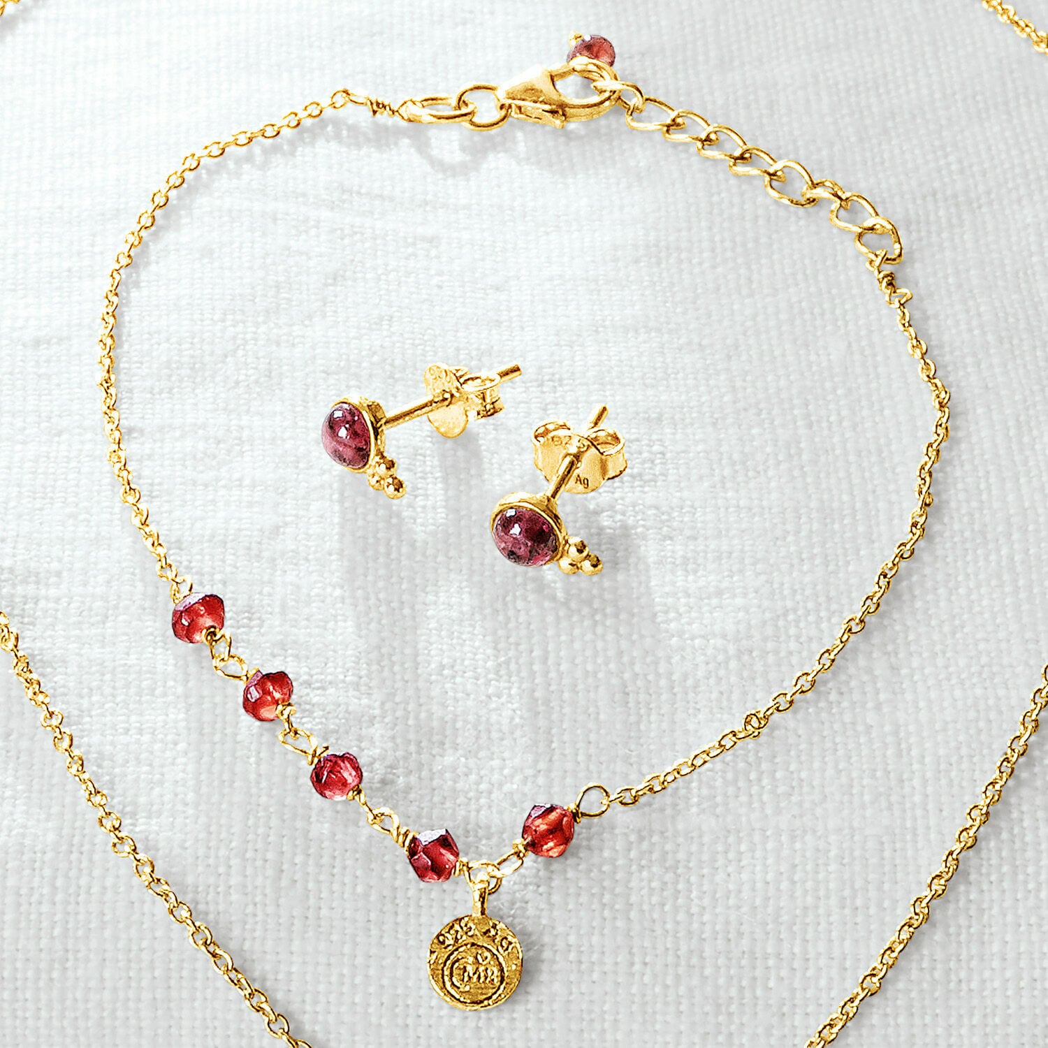 Goldene Halskette und Ohrringe mit roten Steinen, filigraner Damenschmuck an der Kette