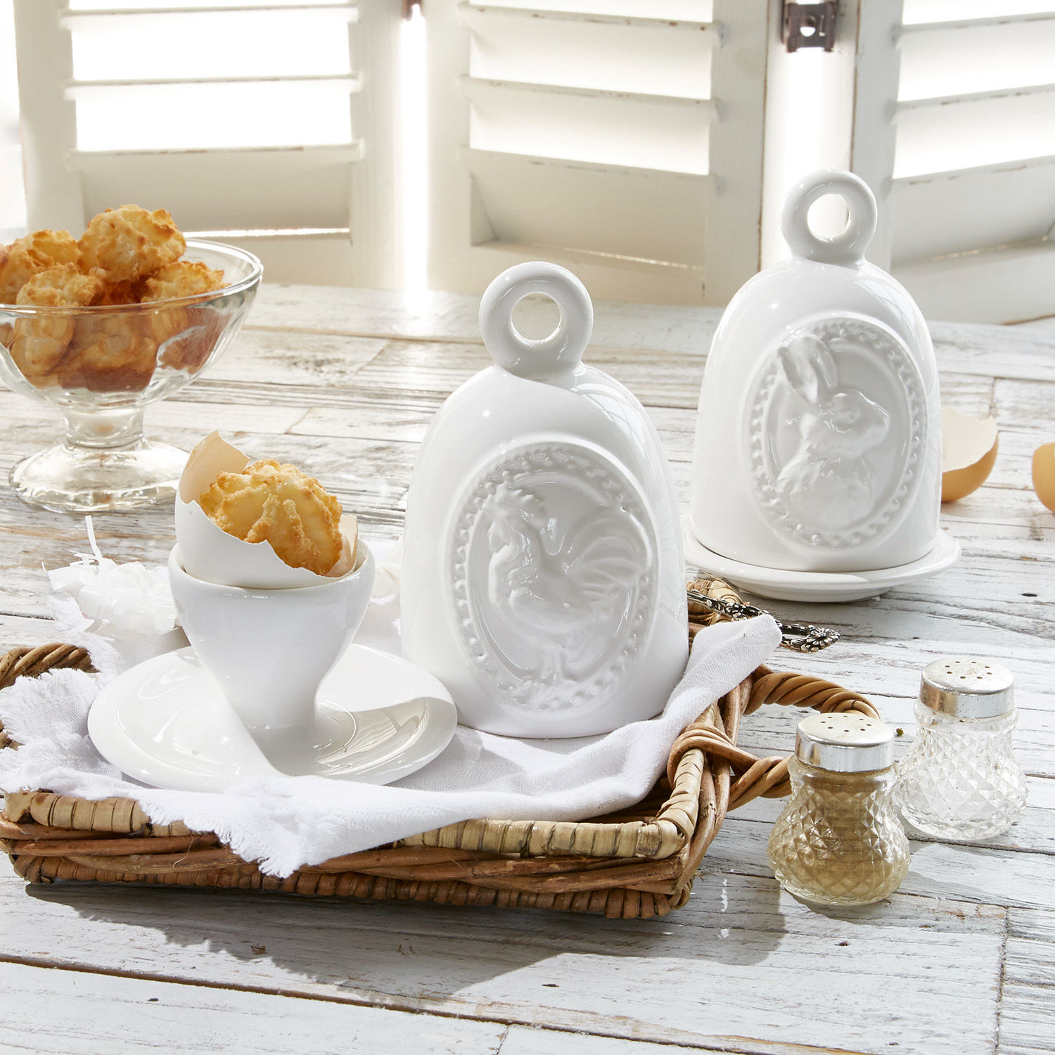 Eierbecher 2er Set Celestyn Weisse Keramikbehälter mit Hahn- und Hasenmotiv auf rustikalem Holztisch mit Snacks