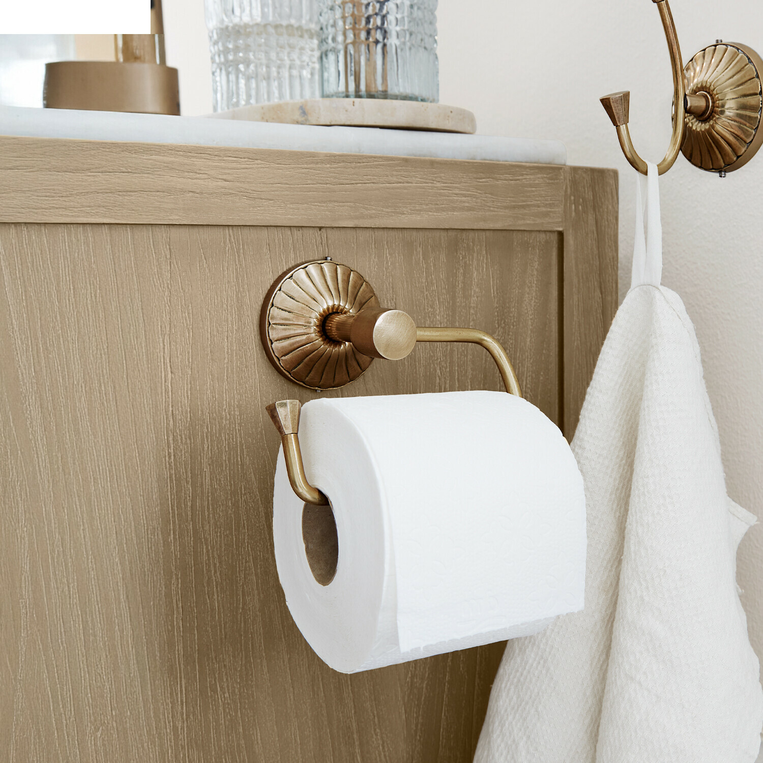 Toilettenpapierhalter Terling Messing Toilettenpapierhalter mit Haken und weissem Handtuch an hellem Holzschrank