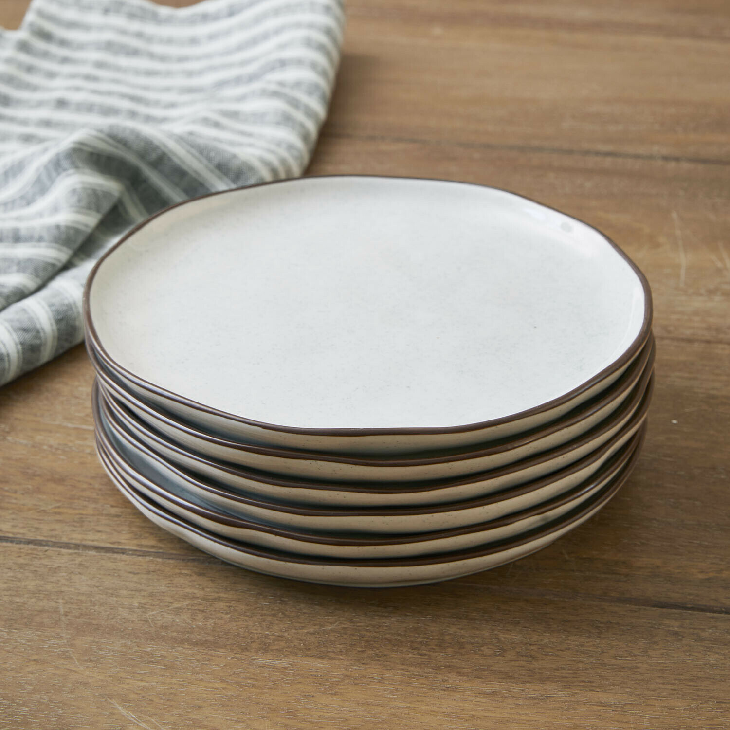 Dessertteller 6er Set Biarré Sechsteiliges Set cremefarbener Keramikteller mit braunem Rand auf Holztisch