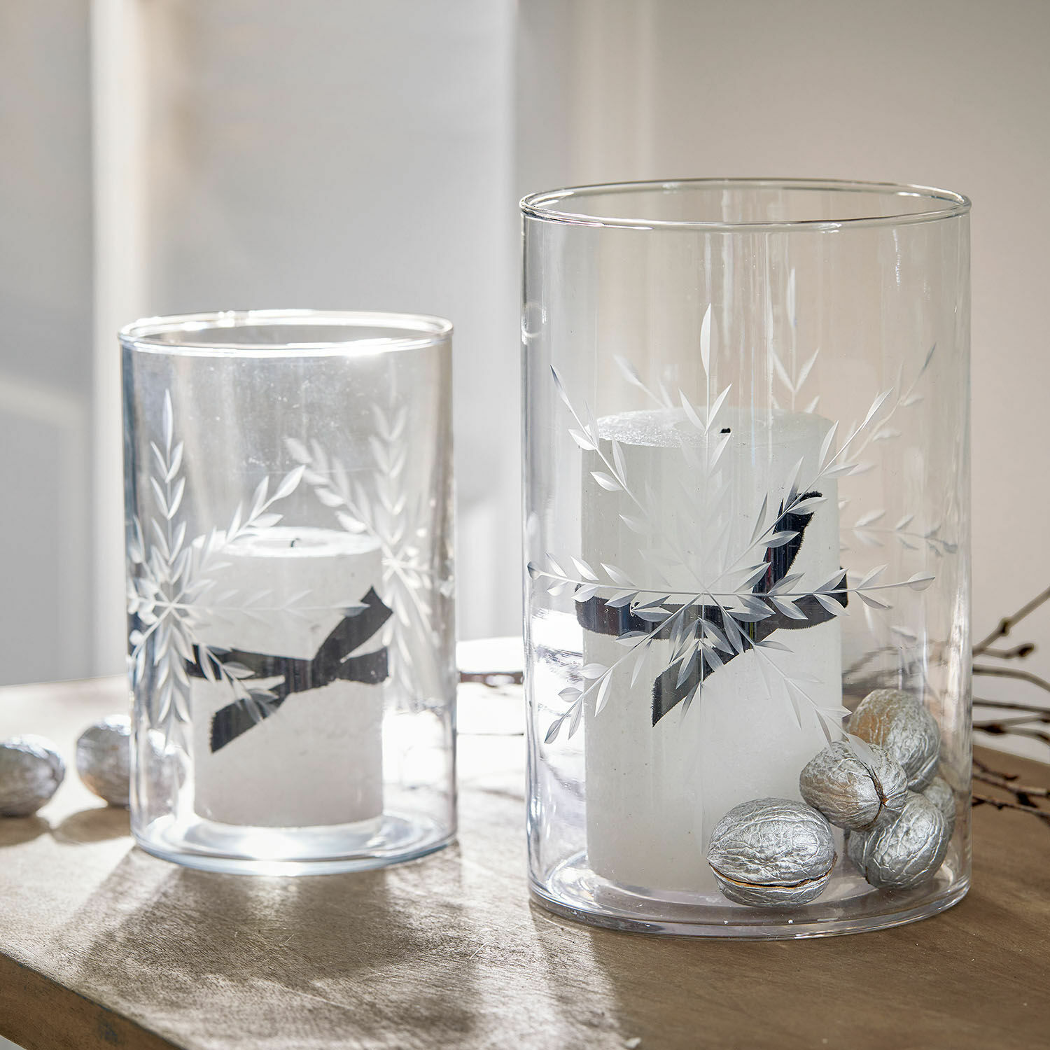 Windlicht 2er Set Snowflakes Glaswindlichter mit weissen Kerzen und silbernen Nüssen auf Holztisch, festliche Dekoration
