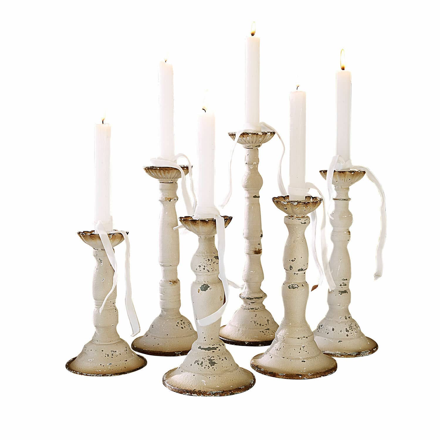Kerzenhalter 6er Set Rivondelle Set aus sieben weissen Metallkerzenhaltern mit antikem Finish und weissen brennenden Kerzen