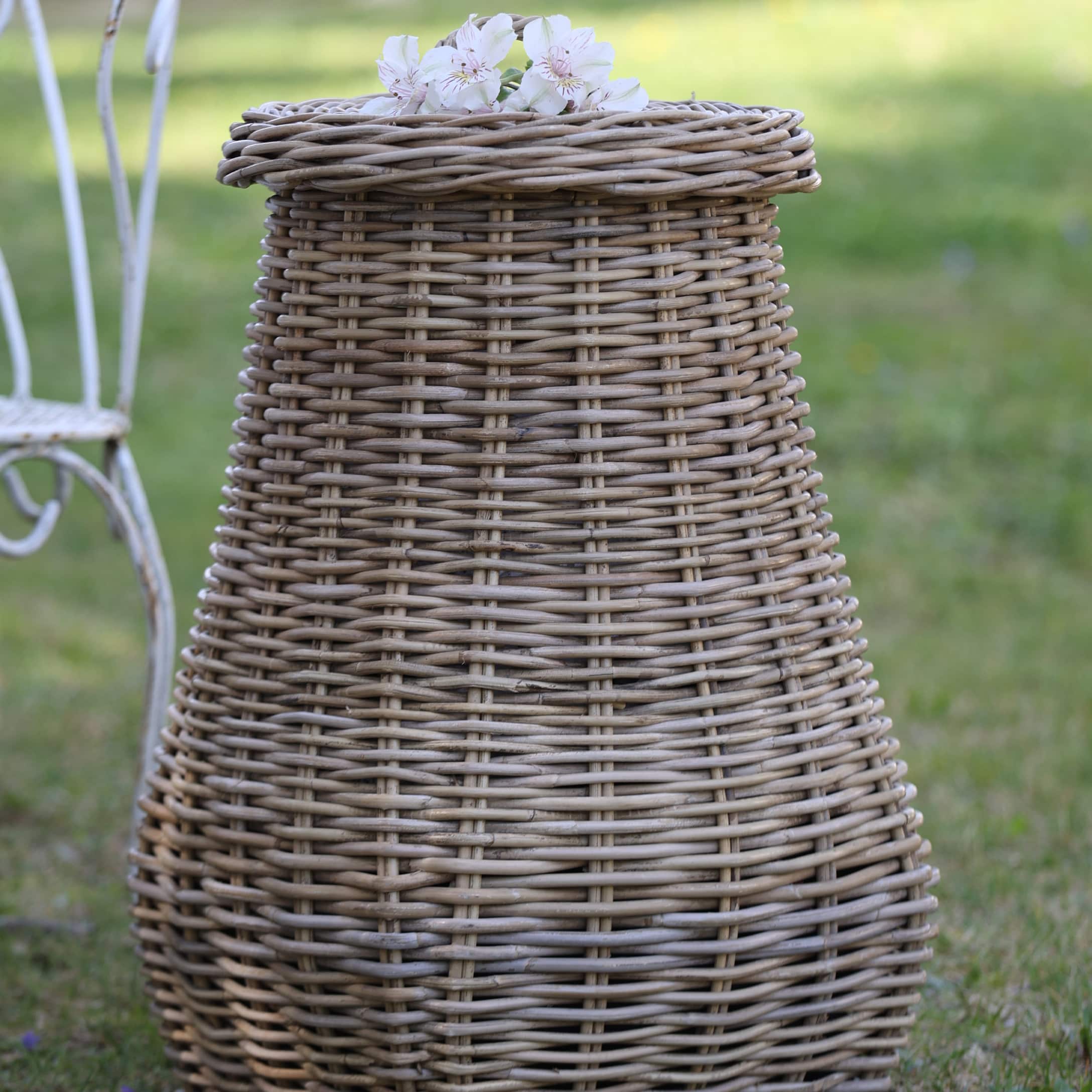 Runder Korb aus natürlichem Rattan mit Blumen auf dem Deckel, dekoratives Gartenobjekt