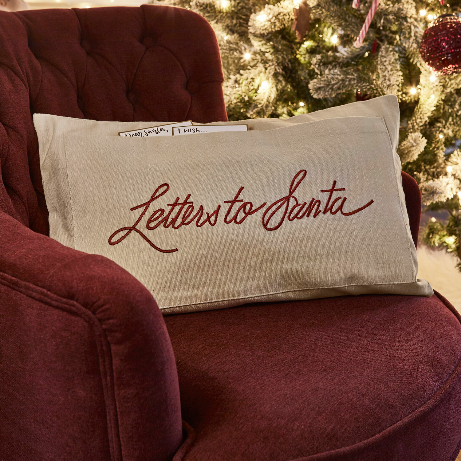 Kissenhülle Welenzas Beiges Leinenkissen mit rotem Schriftzug «Letters to Santa» auf bordeauxrotem Sessel vor Weihnachtsbaum