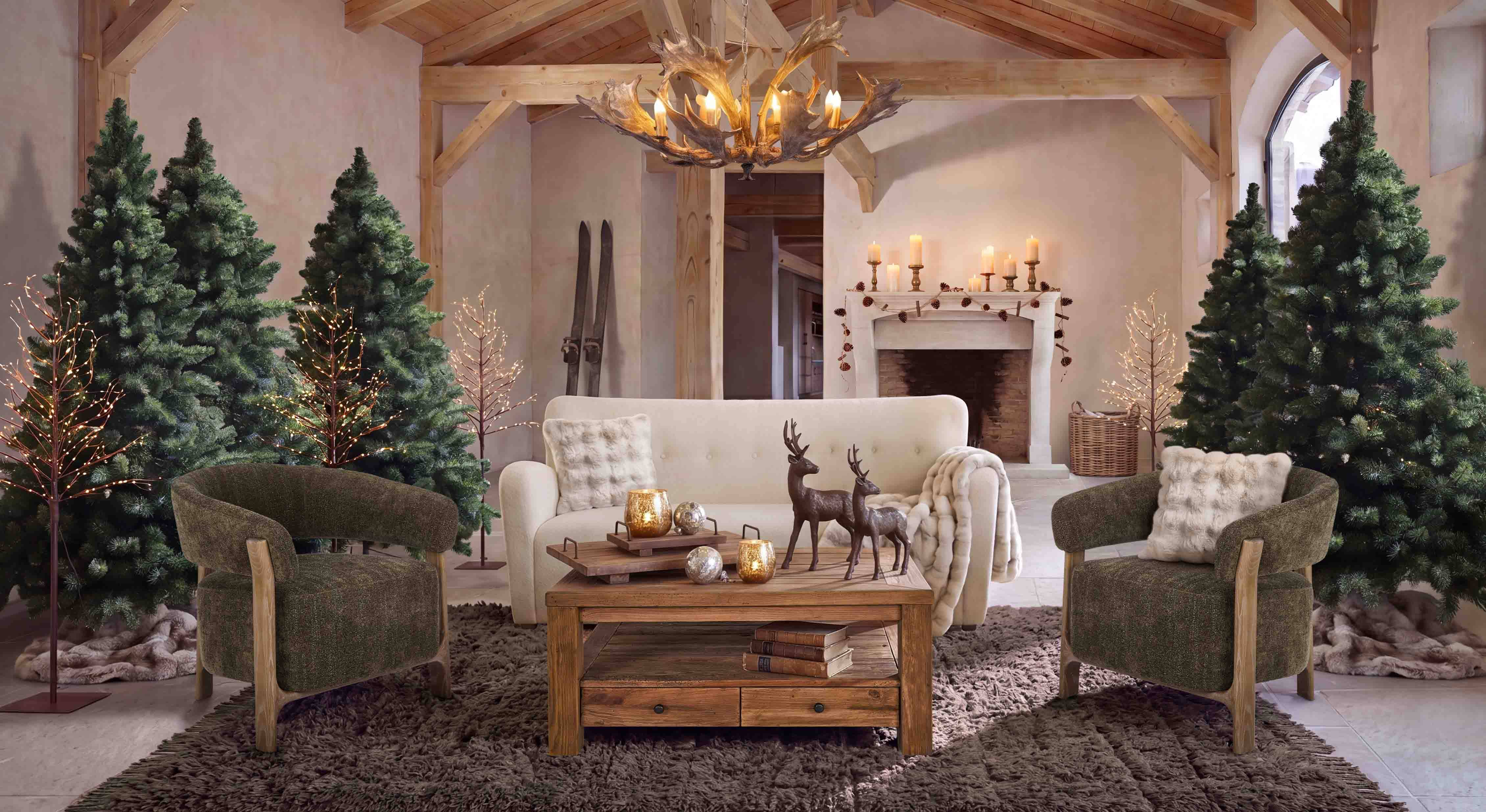 Gemütliches Wohnzimmer mit weissem Sofa, grünen Sesseln und rustikalem Holztisch im Landhausstil