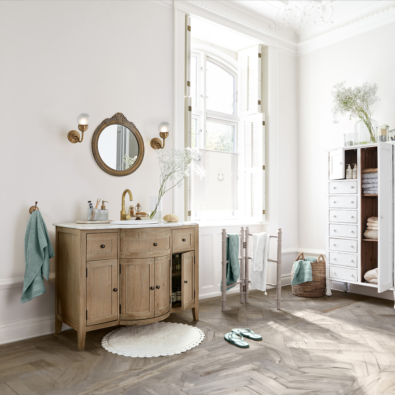 Badezimmer mit Holzwaschbeckenunterschrank, weissem Spiegel und weichen Handtüchern in Pastellfarben