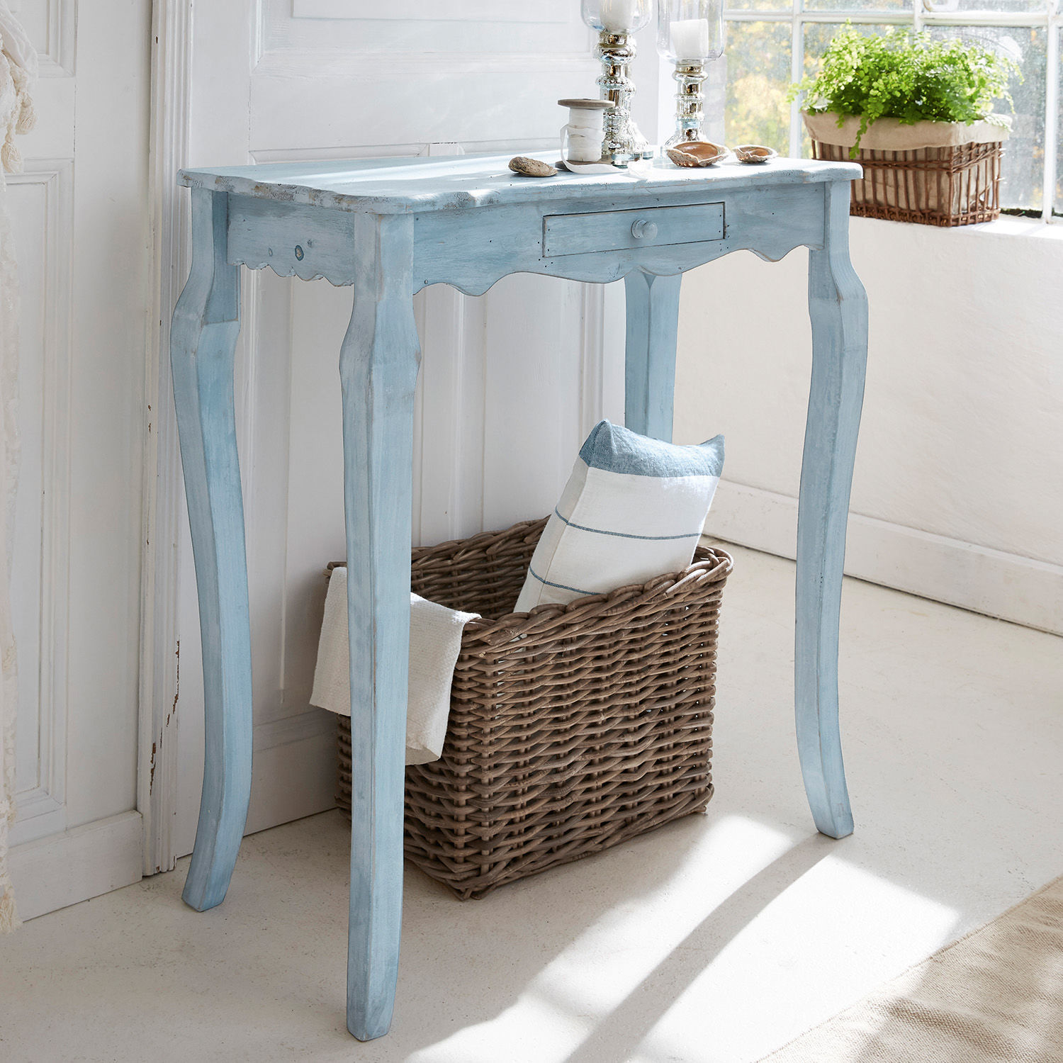 Konsole Barbey Blauer Holztisch im Vintage-Stil mit Schublade und Weidenkorb, dekorativ am Fenster platziert