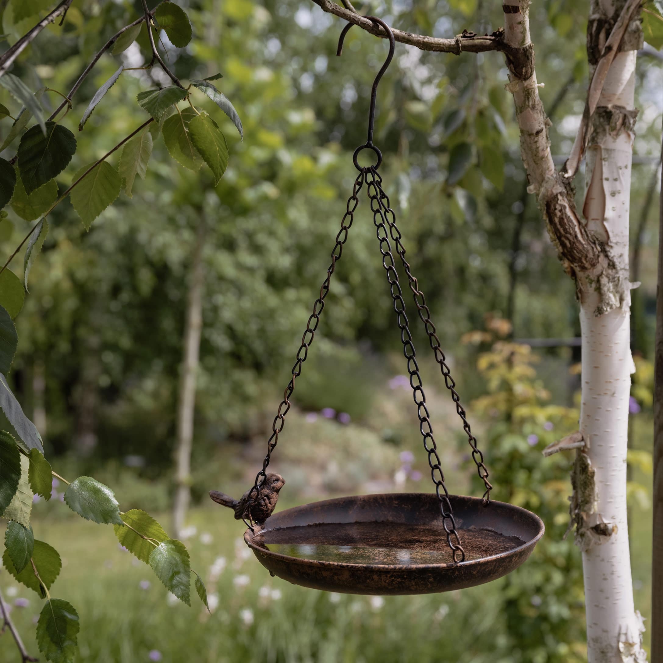 Hängende Metallschale mit dekorativem Vogel, Gartendekoration in Rostoptik