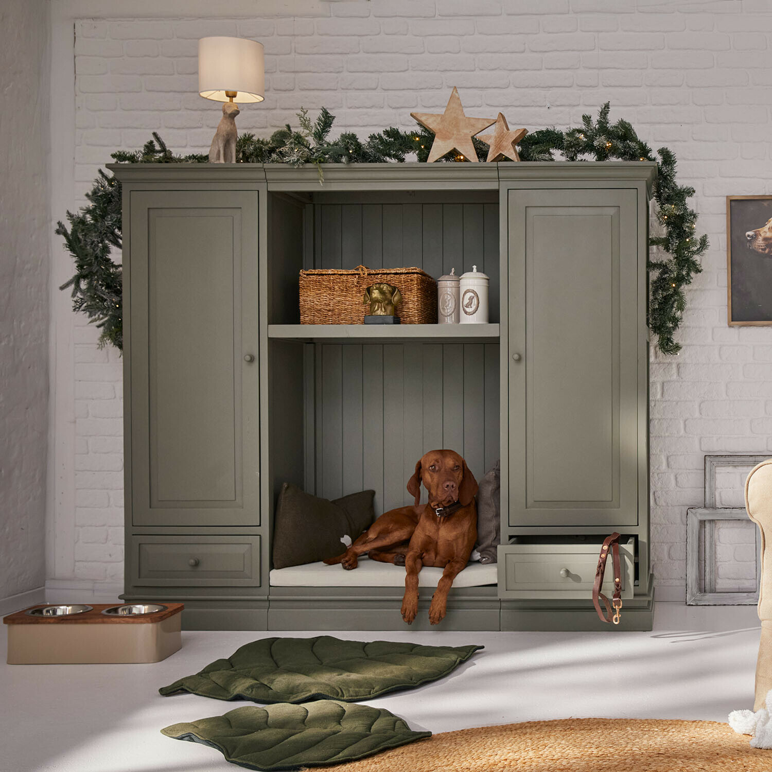 Schrank Stoneleighs Grauer Holzschrank mit Hundeliege und Weihnachtsdekoration in hellem Wohnzimmer