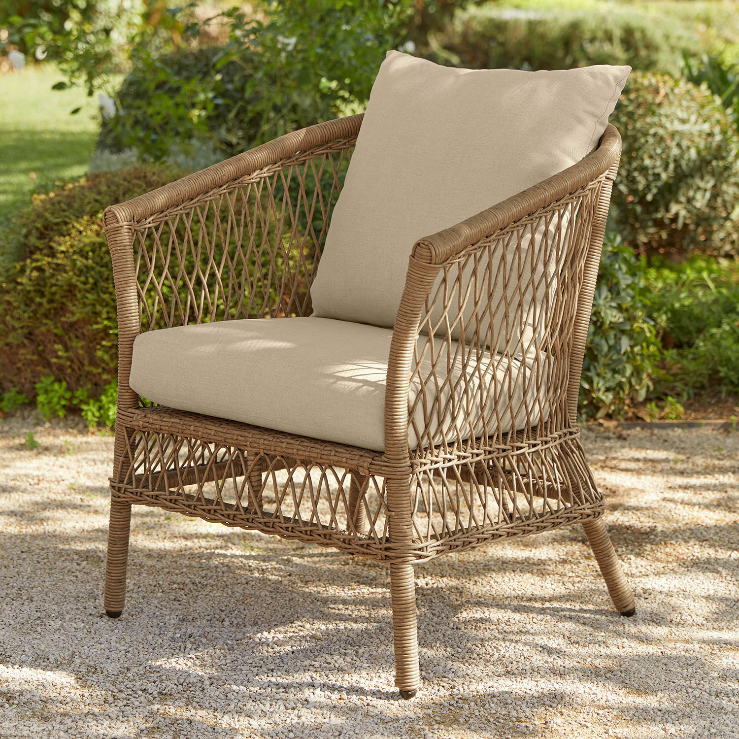 Sessel Farington Gartenstuhl aus natürlichem Rattan mit beigen Polstern, ideal zum Entspannen im Freien.