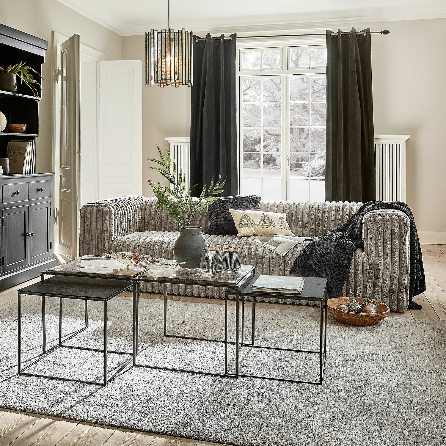 Sofa Roucemont Modernes Wohnzimmer mit grauem Cordsofa und Metall-Couchtischen auf hellem Teppichboden