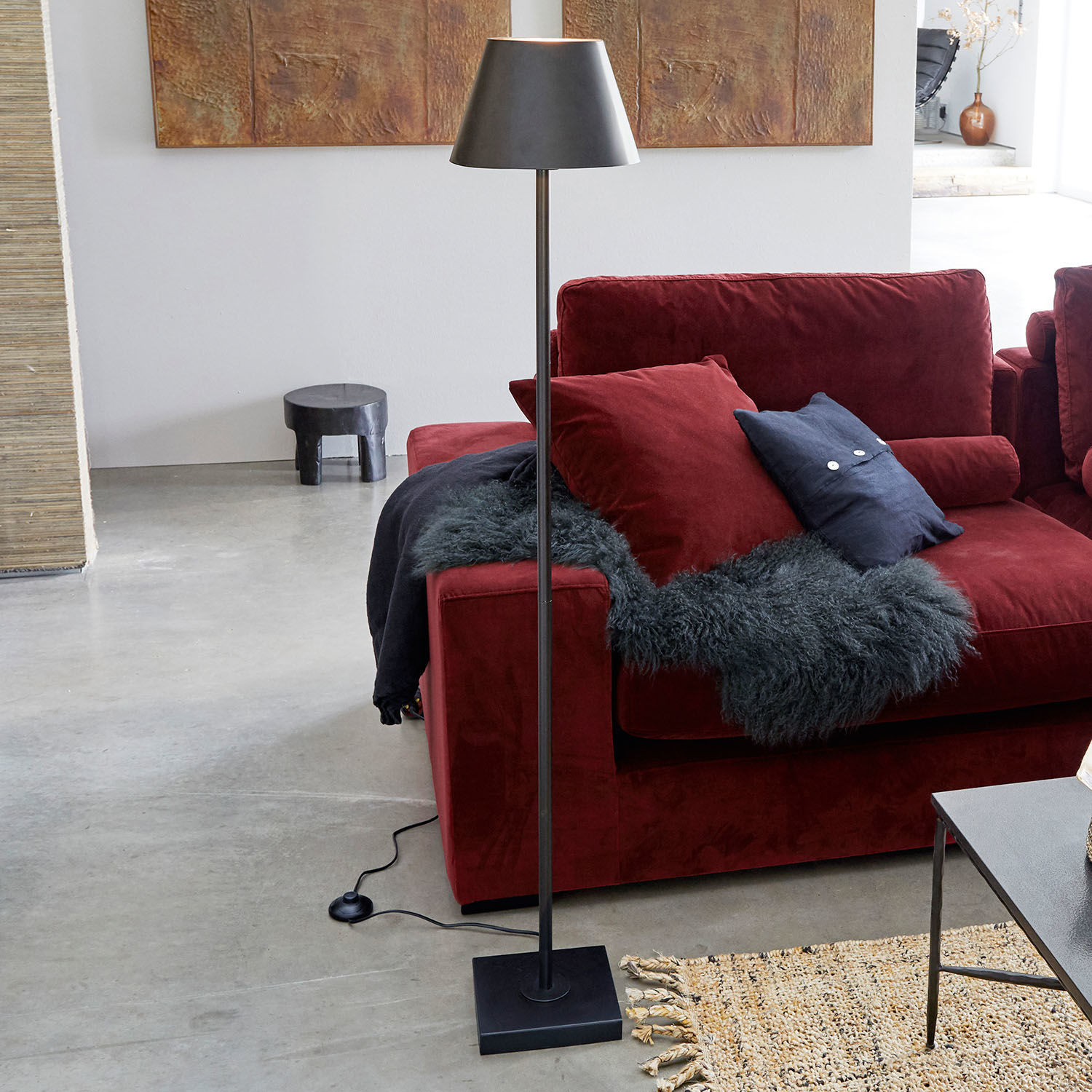 Stehlampe Marjan Schwarze Stehlampe aus Metall mit Lampenschirm neben rotem Sofa und Teppich im modernen Wohnzimmer.