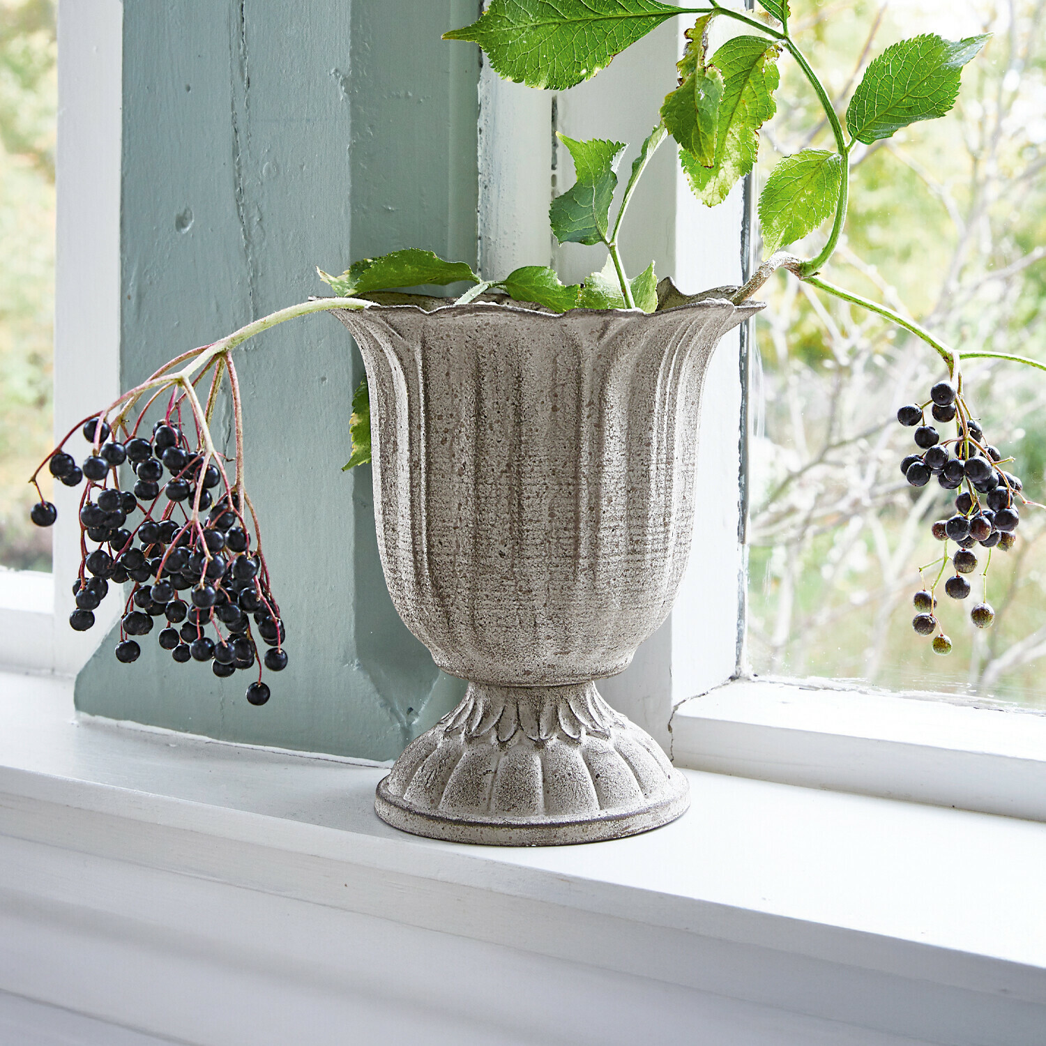 Vase Hanson Graue Keramikvase mit grünen Blättern und Beeren auf der Fensterbank, natürliche Dekoration