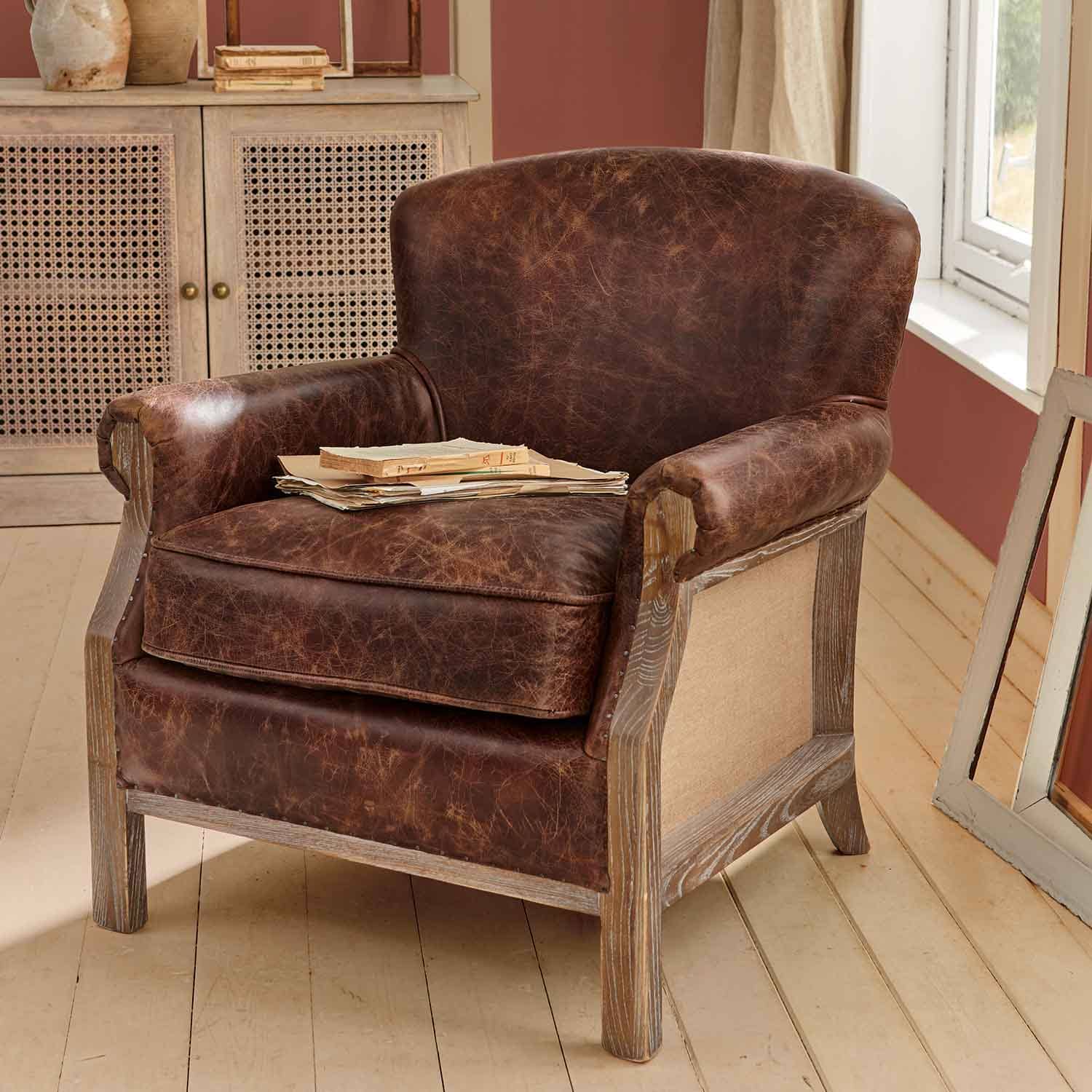 Brauner Ledersessel mit Vintage-Look und Holzrahmen in rustikalem Zimmer mit Büchern