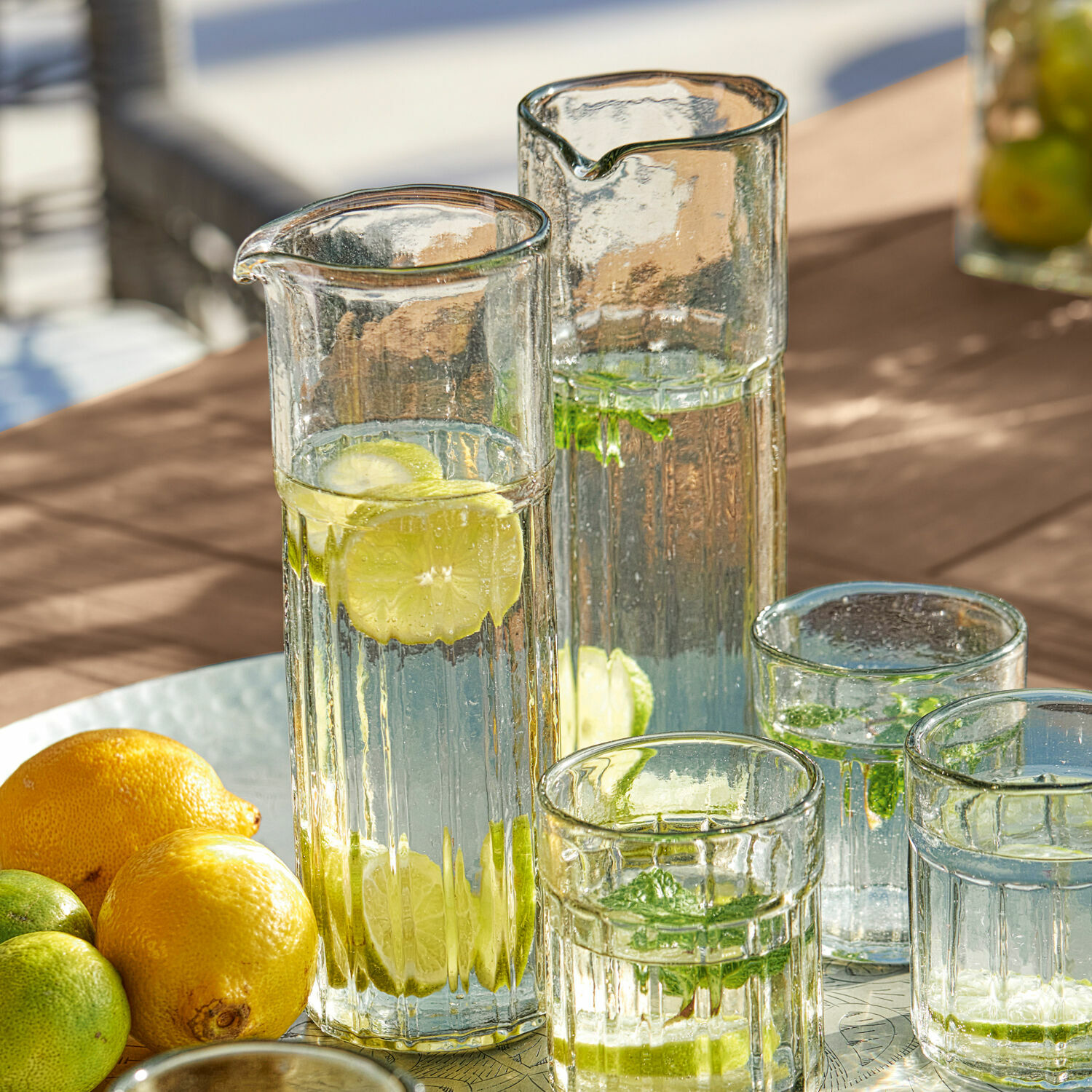 Karaffe 2er Set Roseville Glaskaraffen und Gläser mit Wasser, Zitrone und Minze auf dem Tisch, erfrischendes Sommergetränk