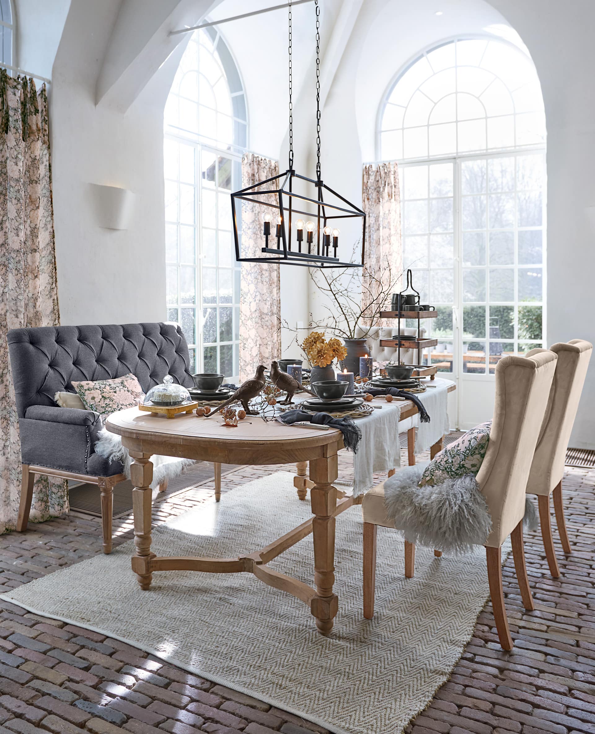 Esszimmer mit Holztisch und gepolsterten Stühlen in Beige und Grau, Tischdekorationen