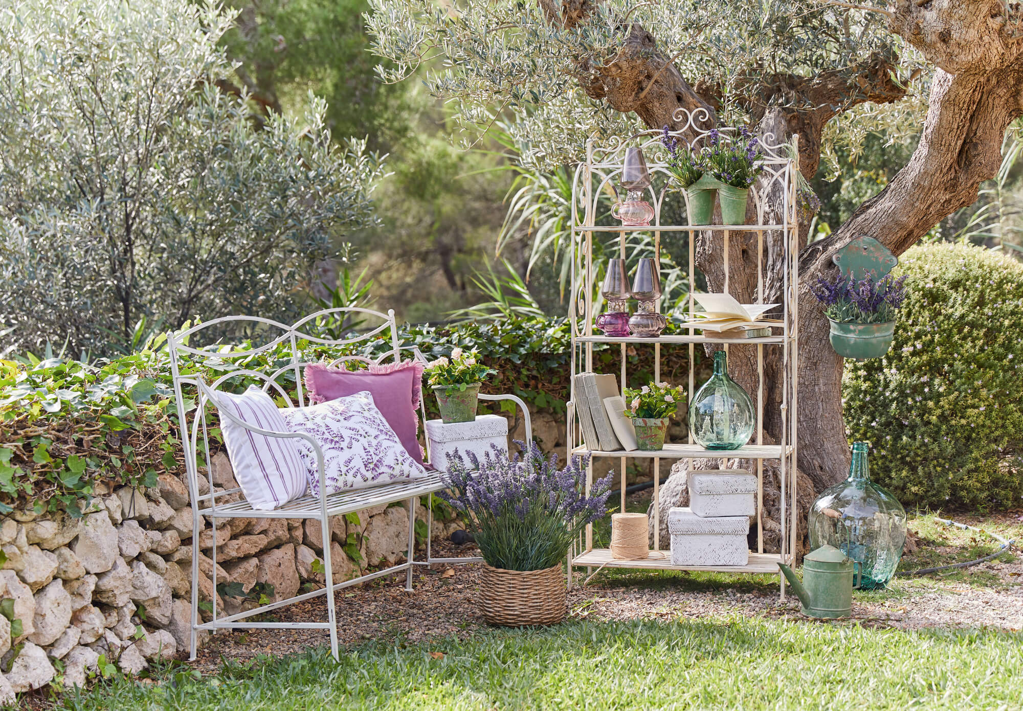 Weisses Metallregal und Gartenbank mit Lavendel und Dekorationen im Garten, rustikales Gartenmöbel