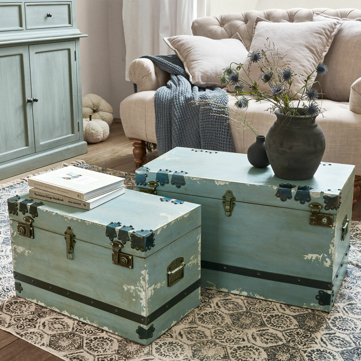 Truhe 2er Set Gorman Zwei blaue Holzkoffer mit Metallbeschlägen auf dem Teppich im Wohnzimmer mit beigem Sofa