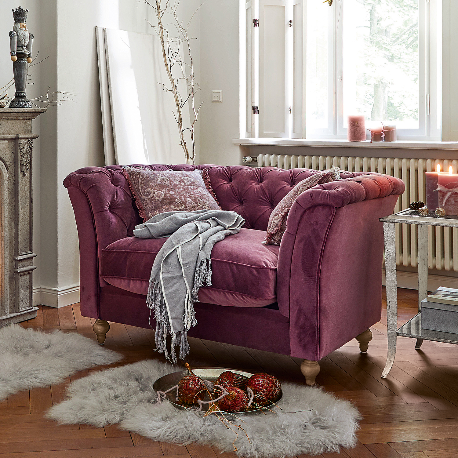 Zweisitziges Samtsofa in Violett mit gesteppter Polsterung und grauem Plaid in gemütlichem Wohnzimmer
