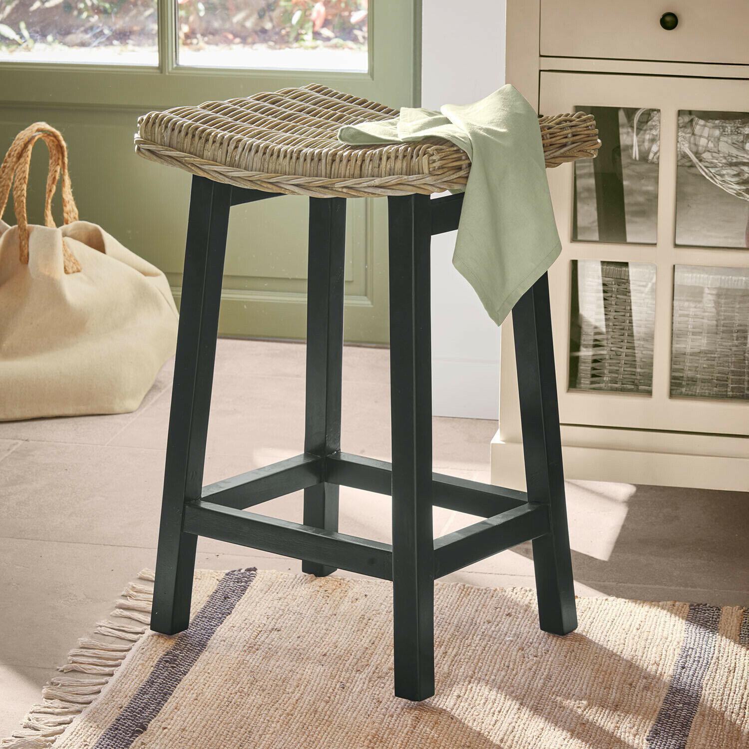 Barhocker mit schwarzen Holzbeinen und geflochtenem hellbraunem Rattansitz