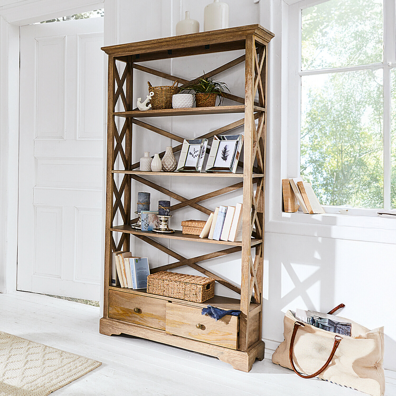 Regal Vélu Regal aus hellem Holz mit Schubladen, Dekorationen und Büchern in hellem Raum.