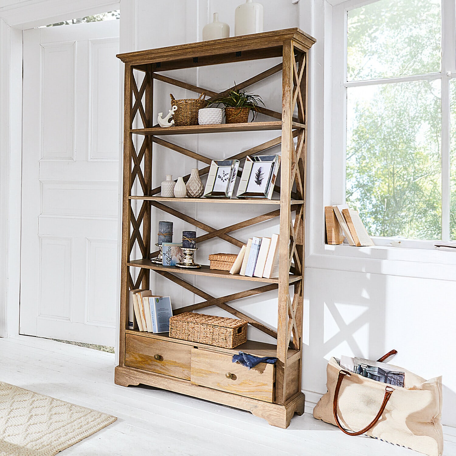 Regal Vélu Regal aus hellem Holz mit Schubladen, Dekorationen und Büchern in hellem Raum.