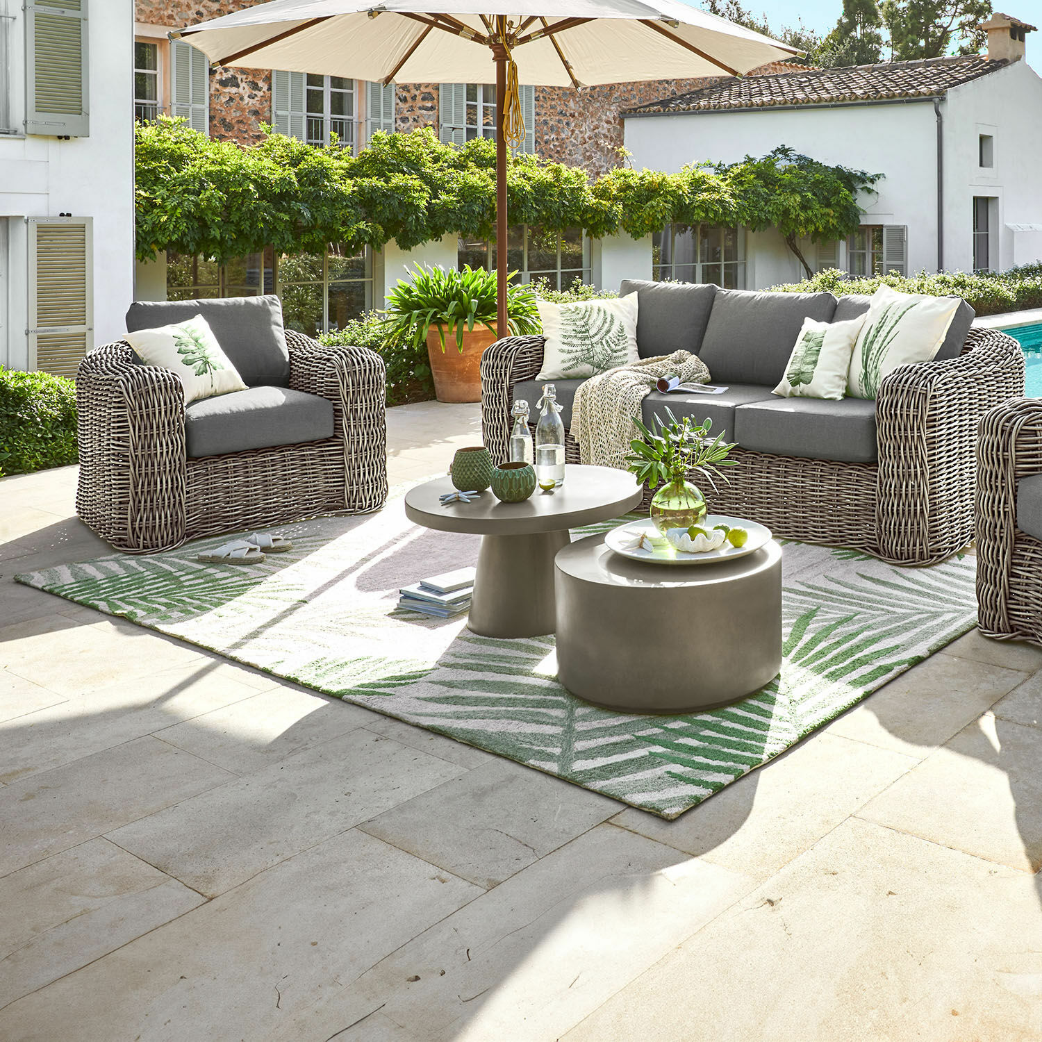 In- & Outdoor-Teppich Marly Gartenmöbel-Set aus grauem Technorattan mit Polstern und Sonnenschirm auf der Terrasse neben dem Pool
