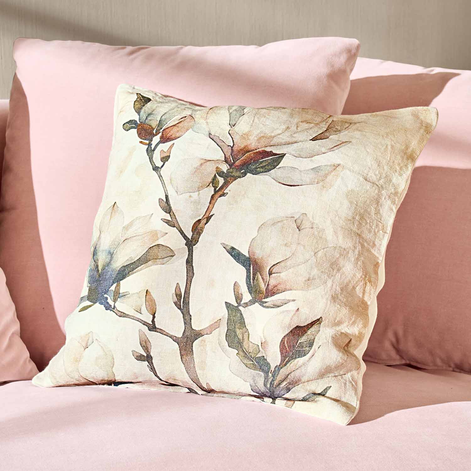 Dekoratives Baumwollkissen mit Blumenmuster auf rosa Bettwäsche, stilvolles Schlafzimmer-Accessoire