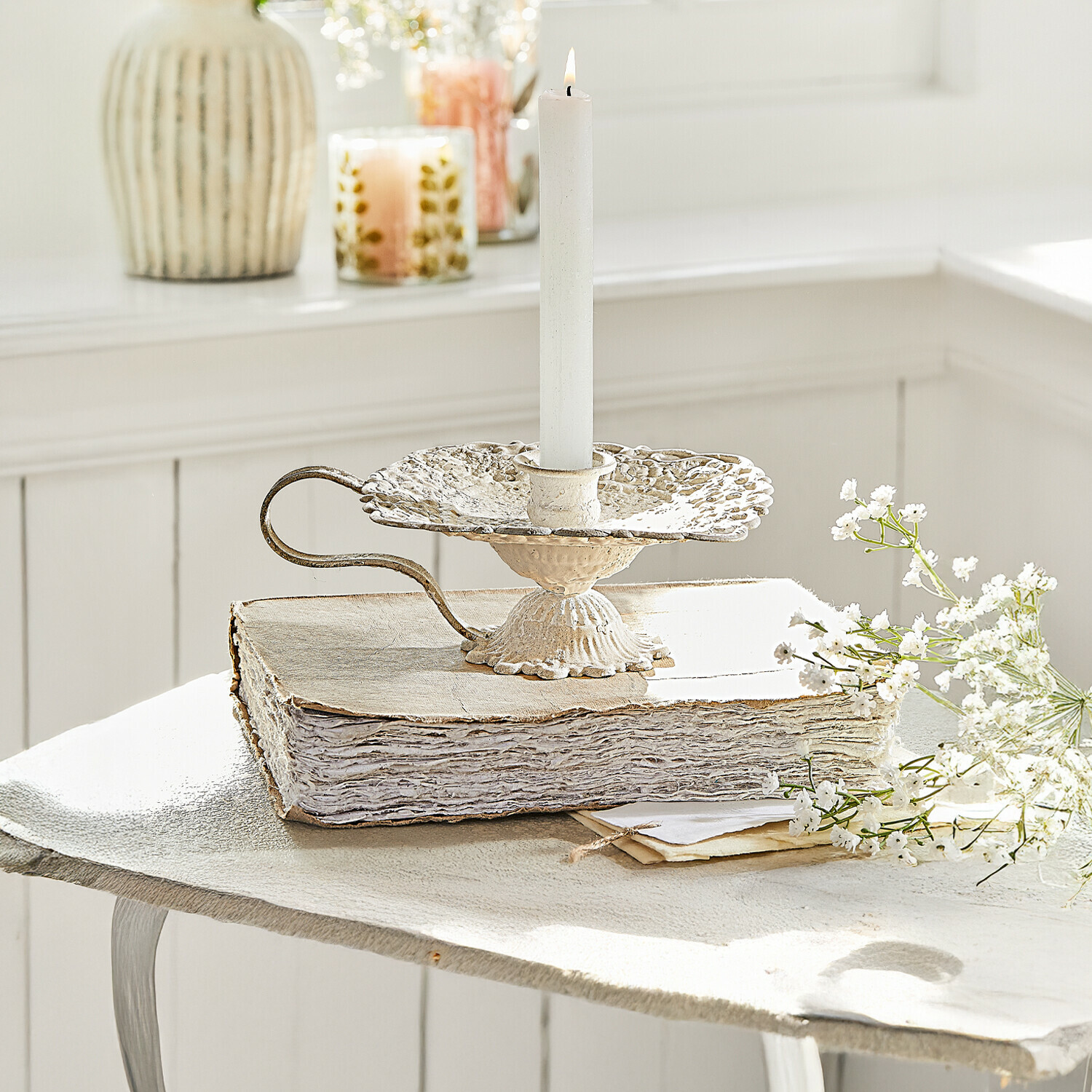 Kerzenhalter Wilexor Vintage-Metallkerzenhalter in Creme mit weisser Kerze, dekorativ auf altem Buch mit Blumen arrangiert
