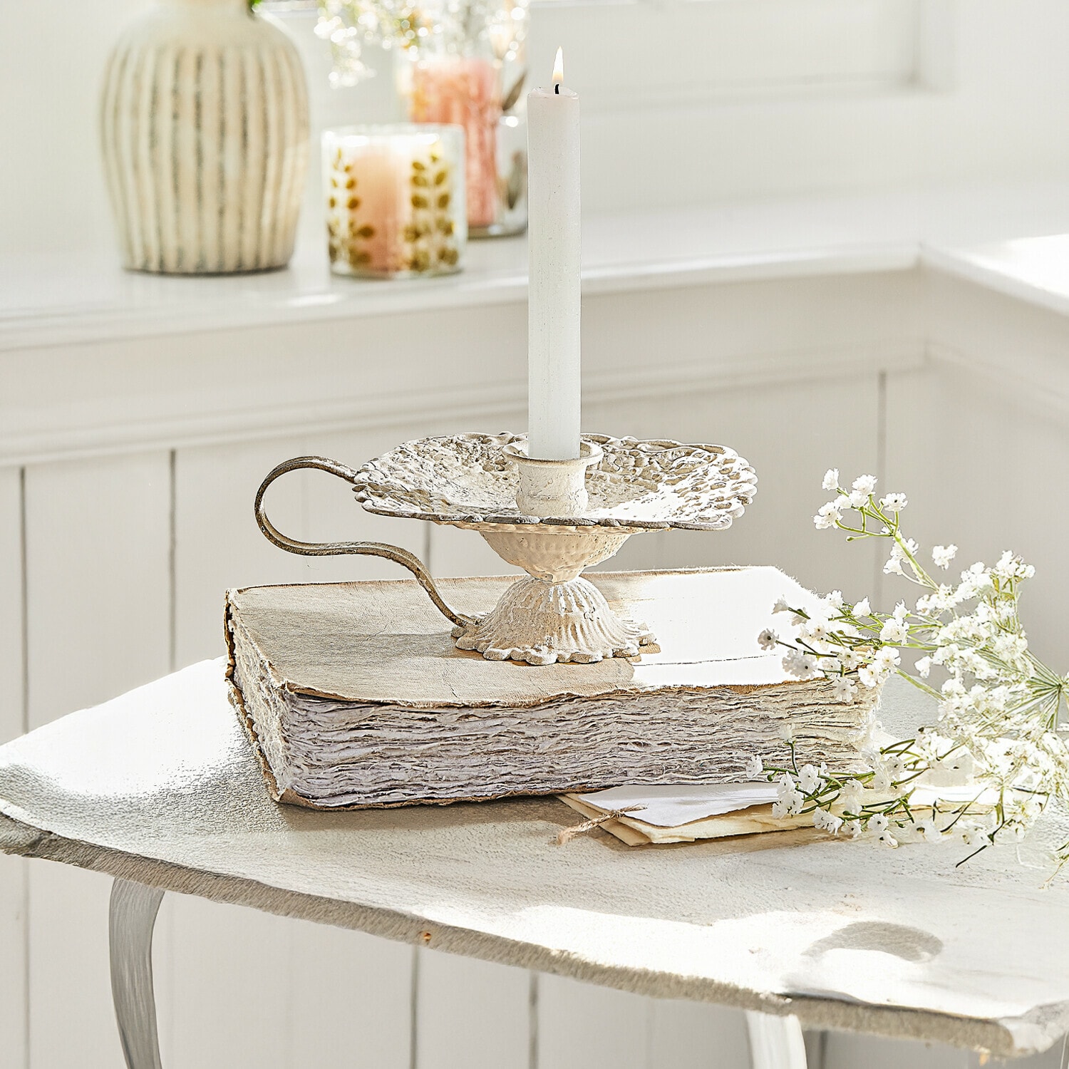 Kerzenhalter Wilexor Vintage-Metallkerzenhalter in Creme mit weisser Kerze, dekorativ auf altem Buch mit Blumen arrangiert