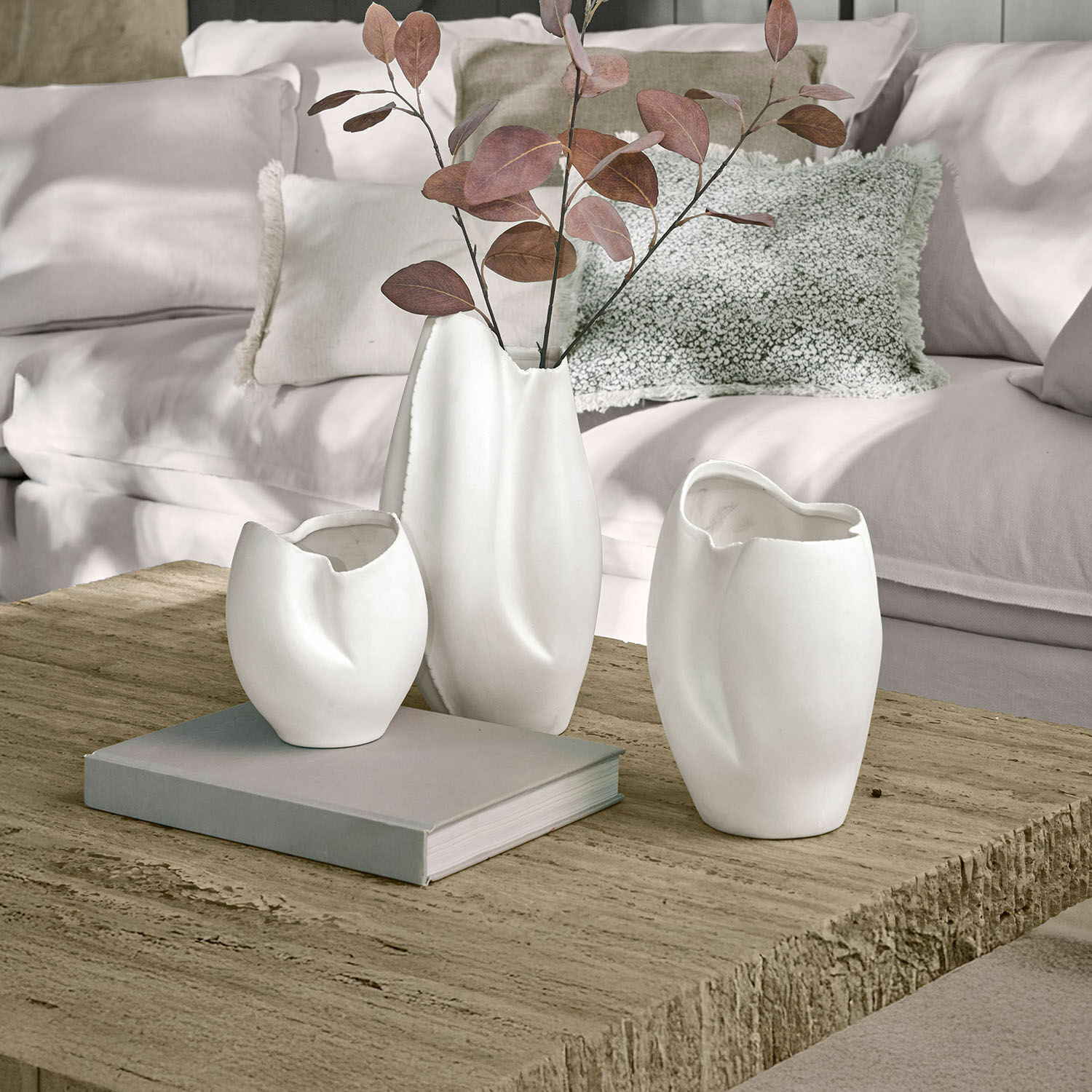 Vase 3er Set Kazimad Drei weiße Keramikvasen mit unregelmässiger Form auf einem Holztisch im Wohnzimmer