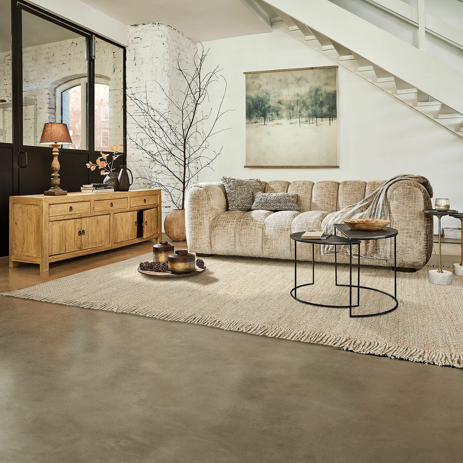 Teppich Levraut Beiges Stoffsofa in modernem Wohnzimmer mit Holzkommode und schwarzen Metall-Couchtischen